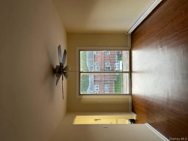 Spare room with a baseboard radiator, dark wood-style floors, and a ceiling fan Spare room with a baseboard radiator, dark wood-style floors, and a ceiling fan