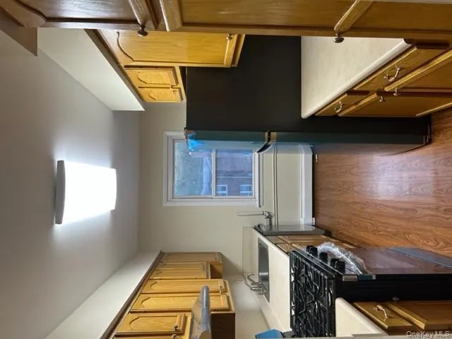Kitchen featuring range, dark wood-style floors, stainless steel fridge, and light countertops Kitchen featuring range, dark wood-style floors, stainless steel fridge, and light countertops
