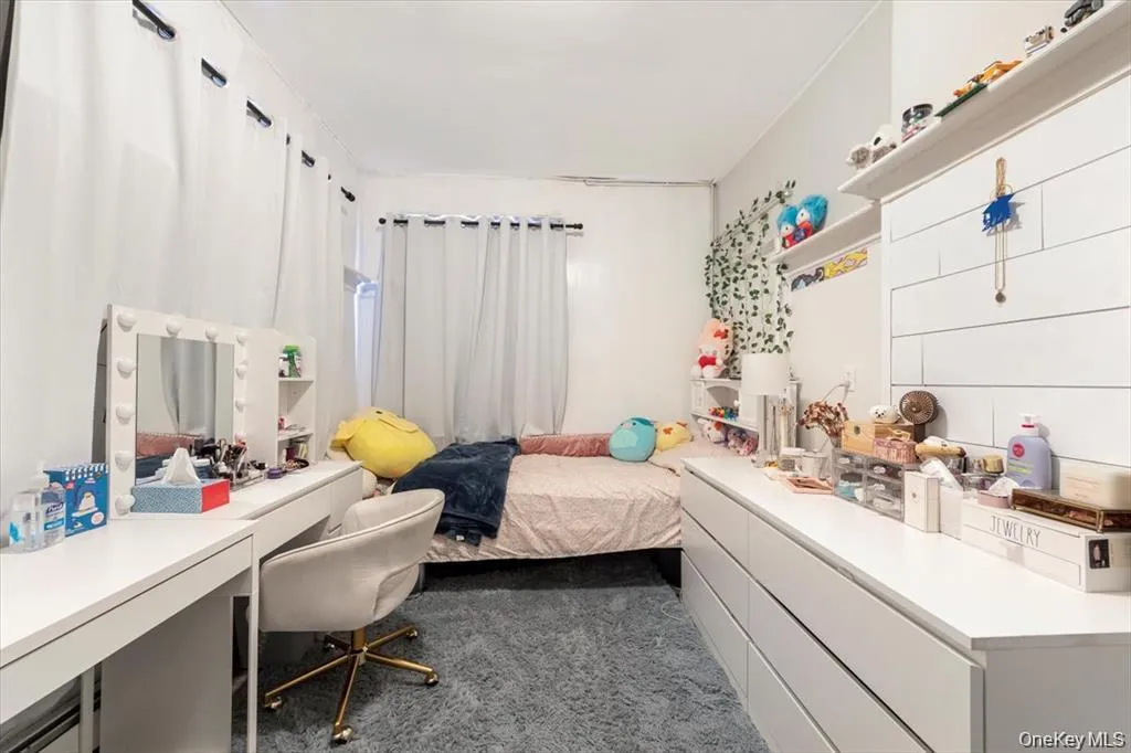 Bedroom featuring dark carpet and a desk Bedroom featuring dark carpet and a desk