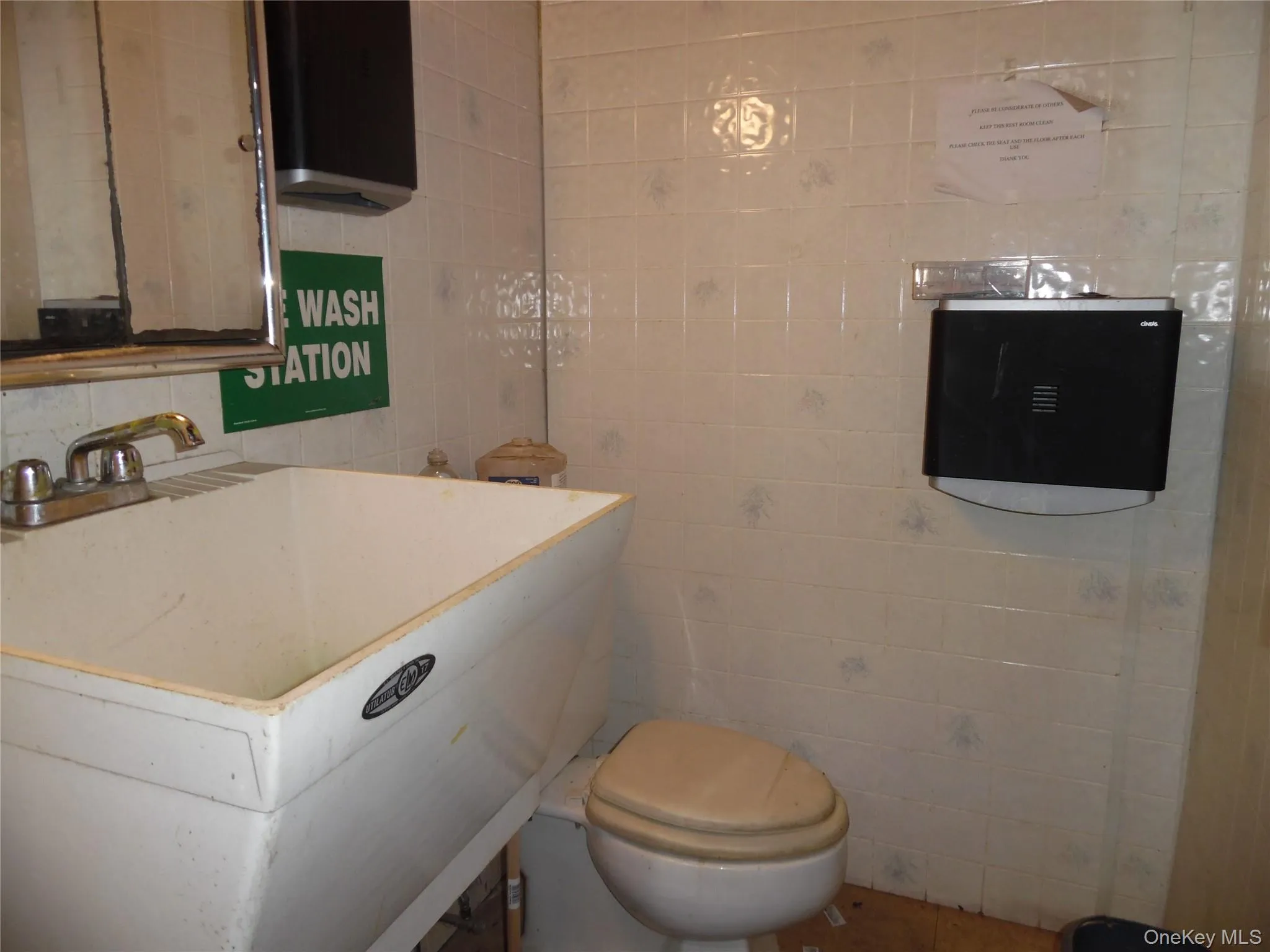 Half bathroom with tile walls and a sink Half bathroom with tile walls and a sink