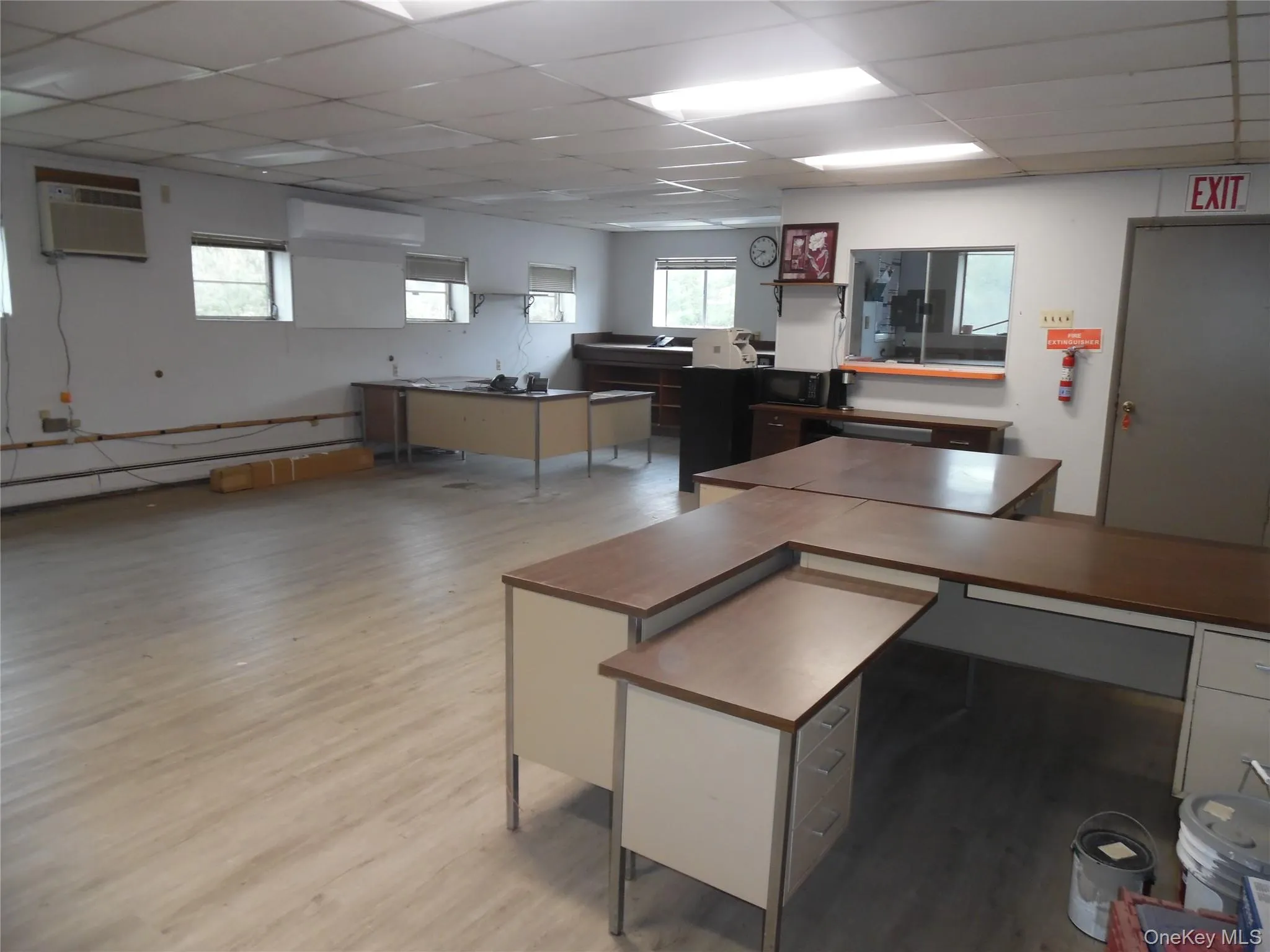 Office featuring a drop ceiling, plenty of natural light, light wood-style flooring, an AC wall unit, and a wall mounted AC Office featuring a drop ceiling, plenty of natural light, light wood-style flooring, an AC wall unit, and a wall mounted AC