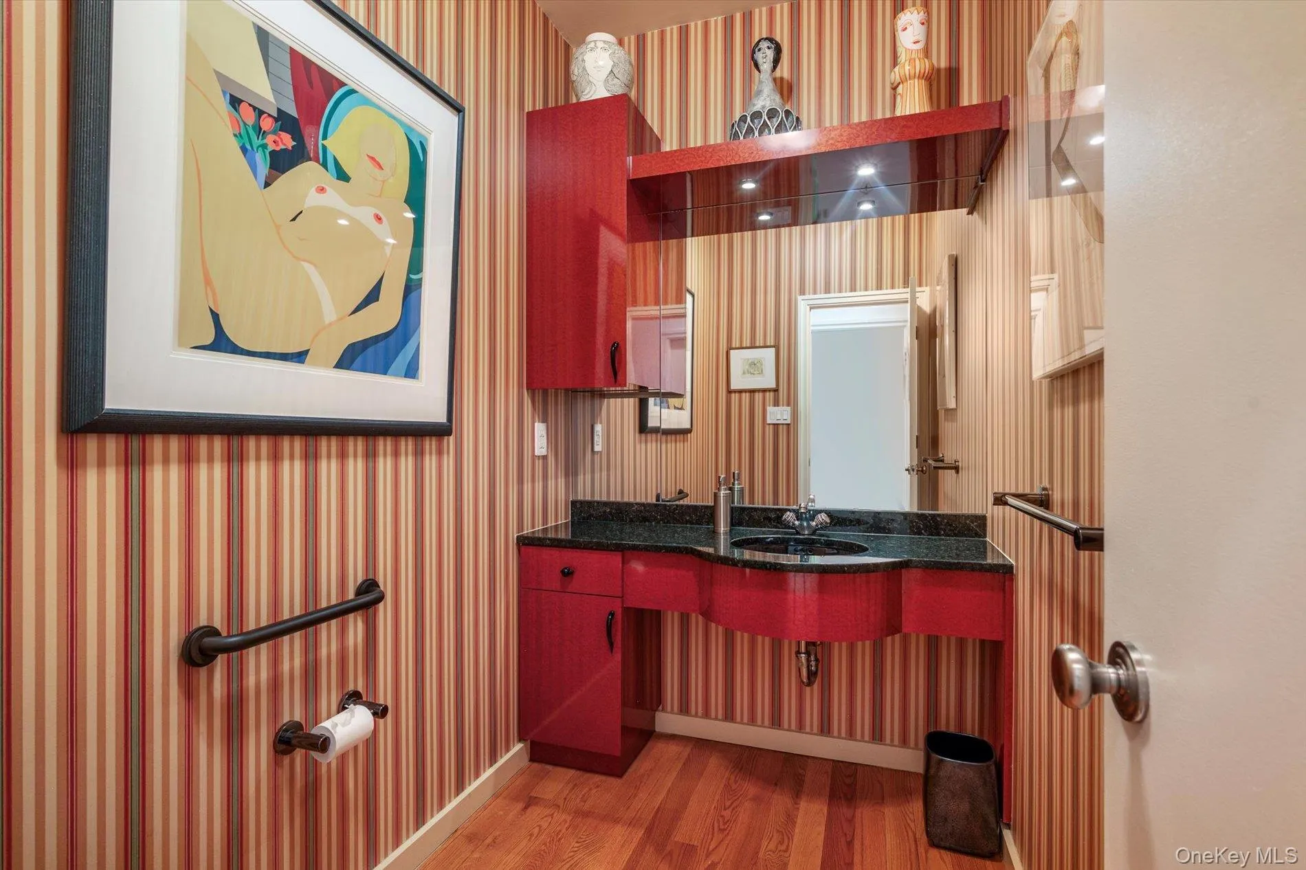 Bathroom featuring light wood-style floors, wallpapered walls, and vanity Bathroom featuring light wood-style floors, wallpapered walls, and vanity