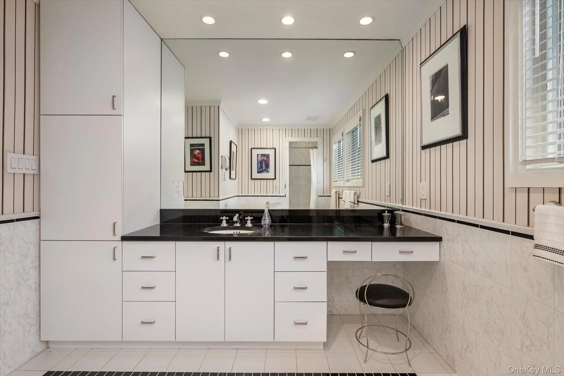 Bathroom with tile walls, double vanity, recessed lighting, light tile patterned floors, and crown molding Bathroom with tile walls, double vanity, recessed lighting, light tile patterned floors, and crown molding