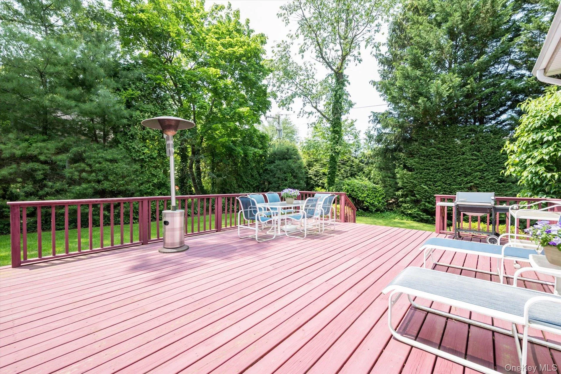 Deck with outdoor dining area, view of scattered trees, and area for grilling Deck with outdoor dining area, view of scattered trees, and area for grilling