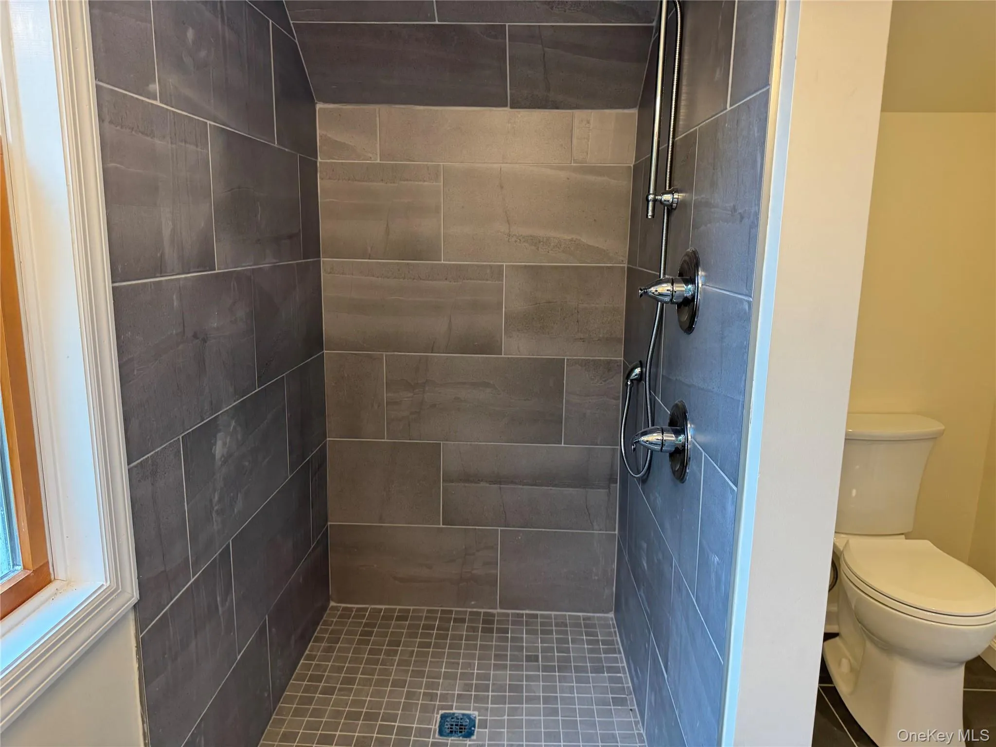 Bathroom featuring a stall shower and toilet Bathroom featuring a stall shower and toilet