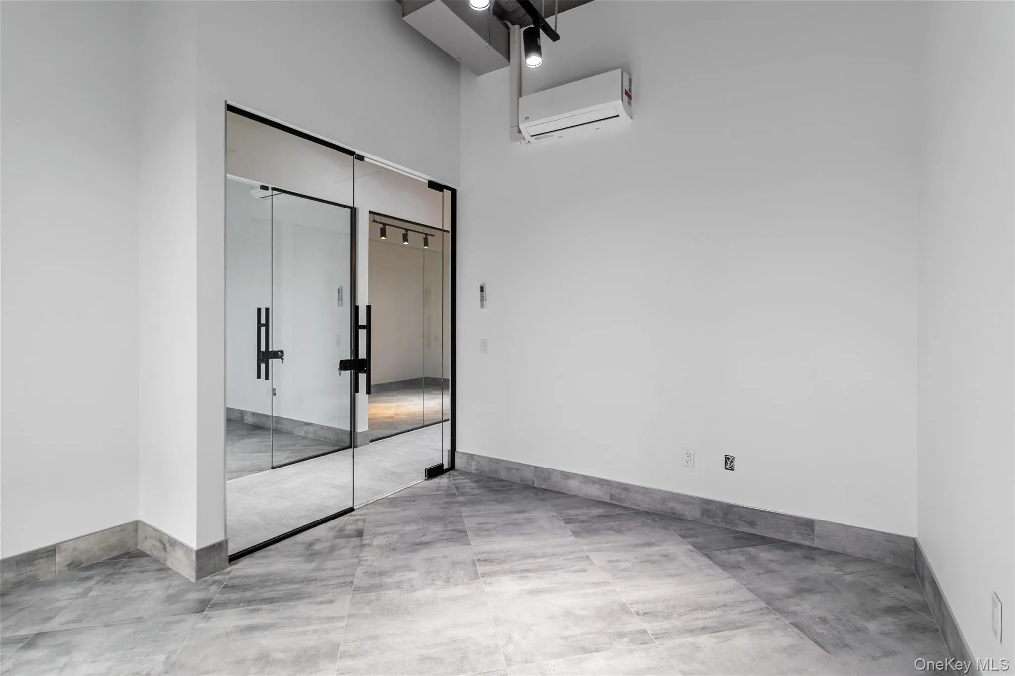 Unfurnished bedroom with a closet, a wall mounted AC, and a high ceiling Unfurnished bedroom with a closet, a wall mounted AC, and a high ceiling