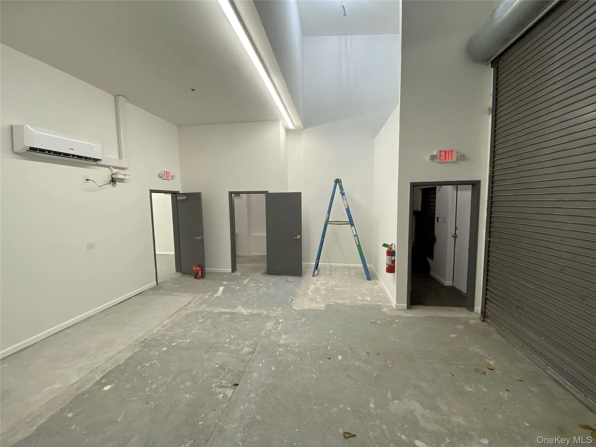 Garage with a wall unit AC and baseboards Garage with a wall unit AC and baseboards