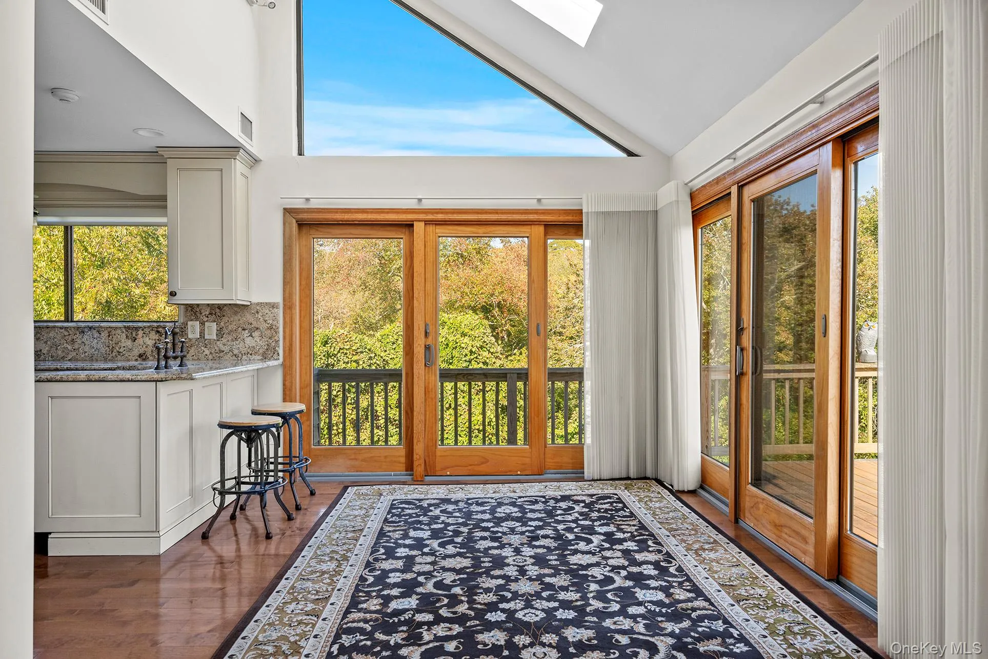 Dining area with double sliders to wrap around deck and all the natural light, a skylight, and high vaulted ceiling. Dining area with double sliders to wrap around deck and all the natural light, a skylight, and high vaulted ceiling.