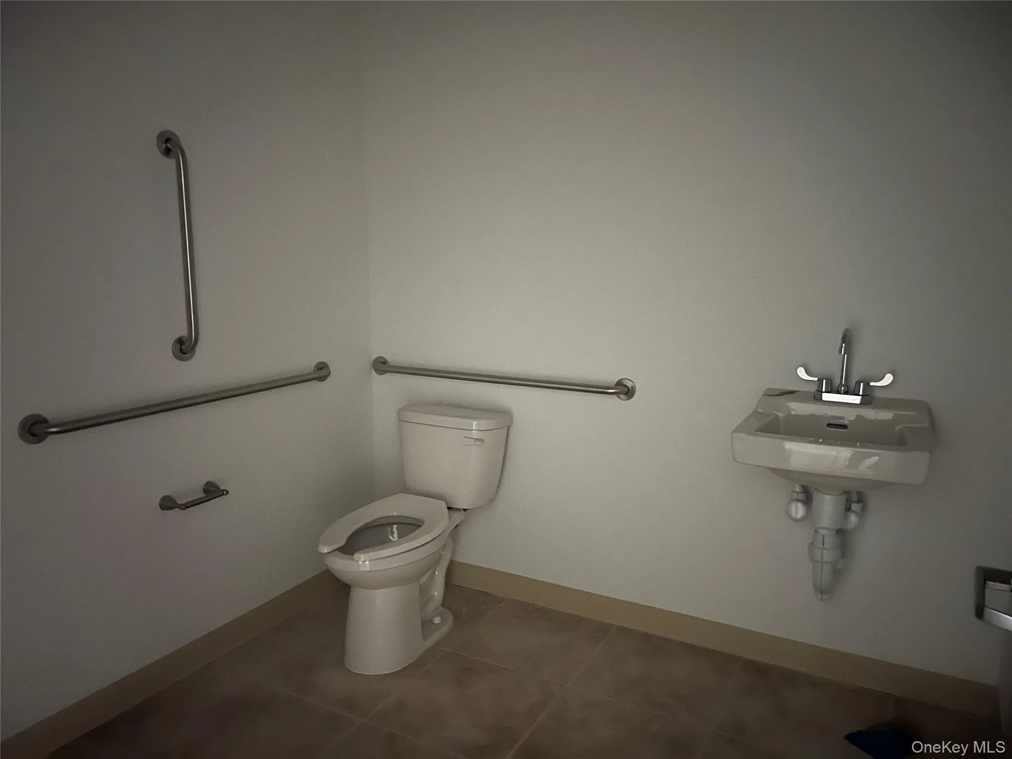 Bathroom featuring toilet and dark tile patterned floors Bathroom featuring toilet and dark tile patterned floors