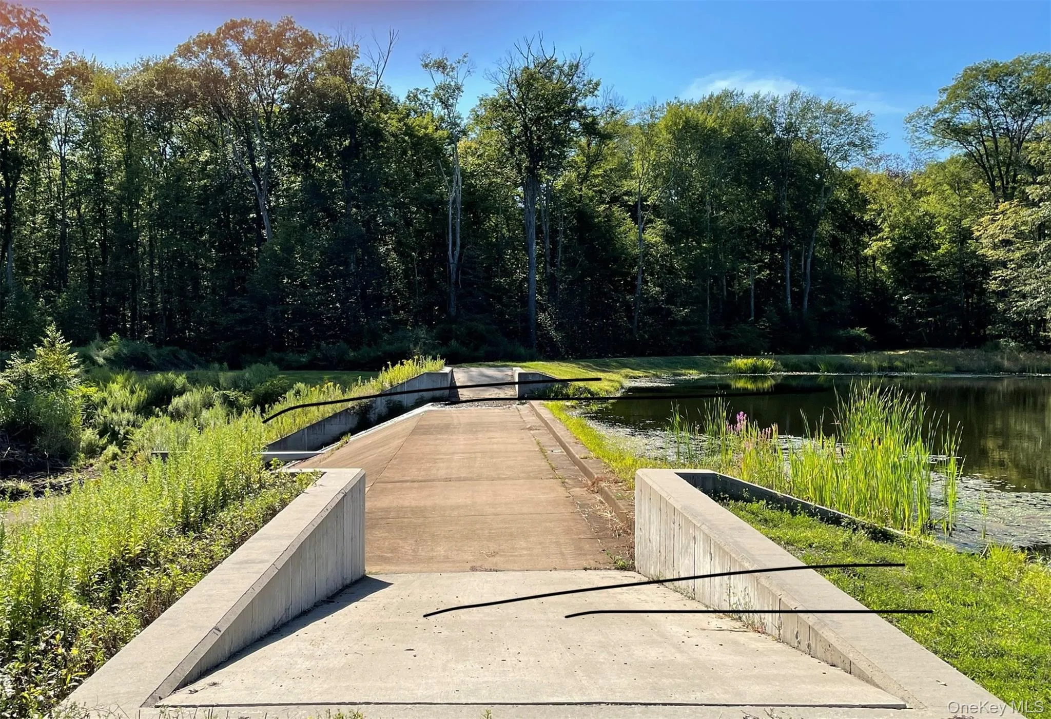 View of property's community featuring a wooded view, a water view, and a boat ramp View of property's community featuring a wooded view, a water view, and a boat ramp