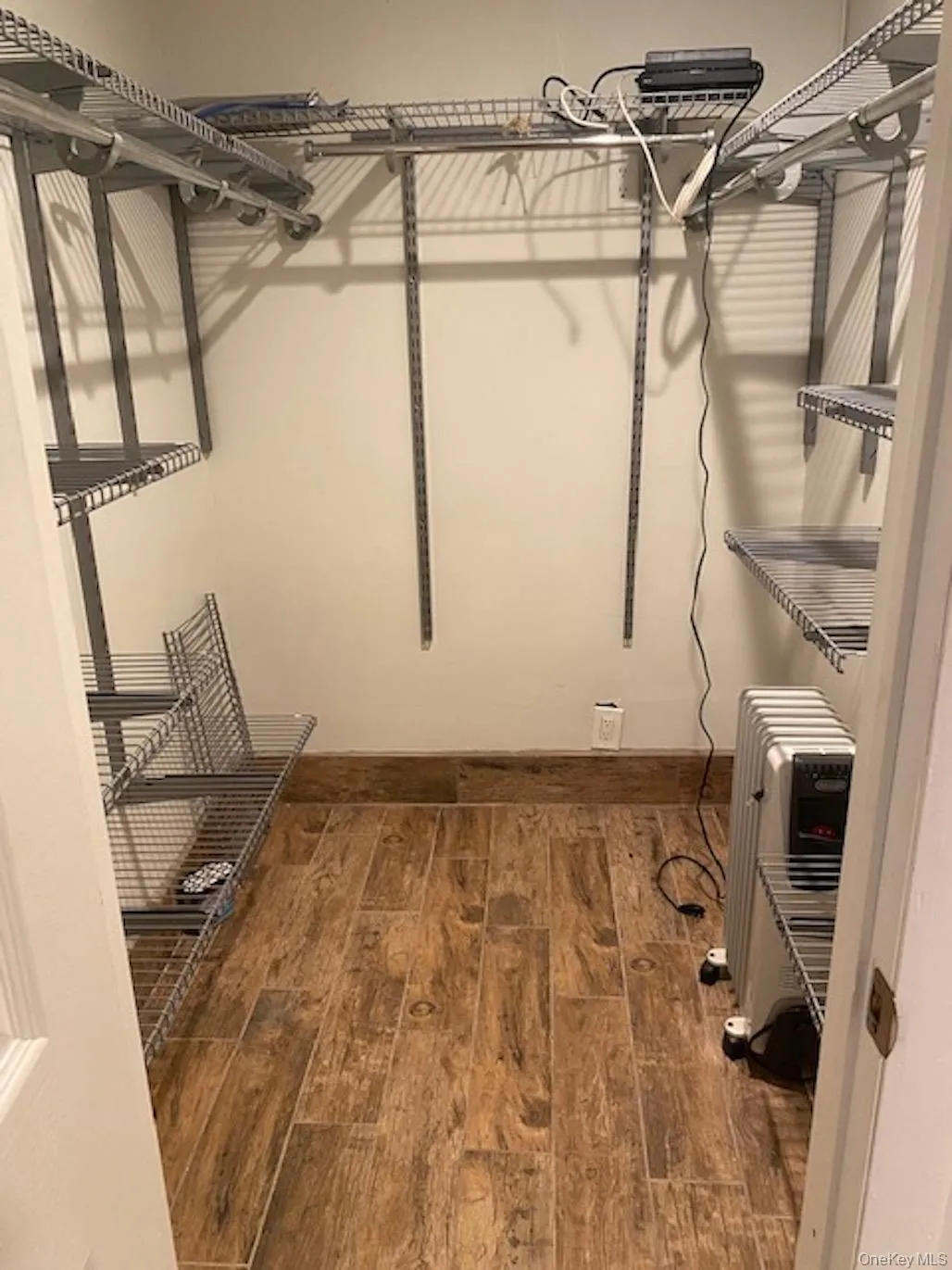 Spacious closet featuring heating unit and wood finished floors Spacious closet featuring heating unit and wood finished floors
