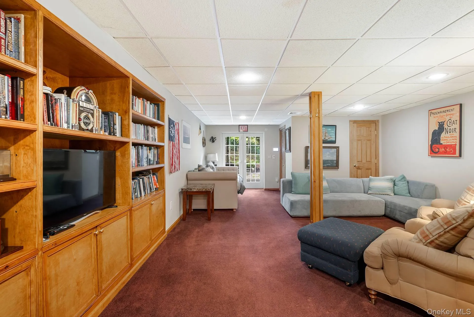 Living area with dark carpet and a paneled ceiling Living area with dark carpet and a paneled ceiling