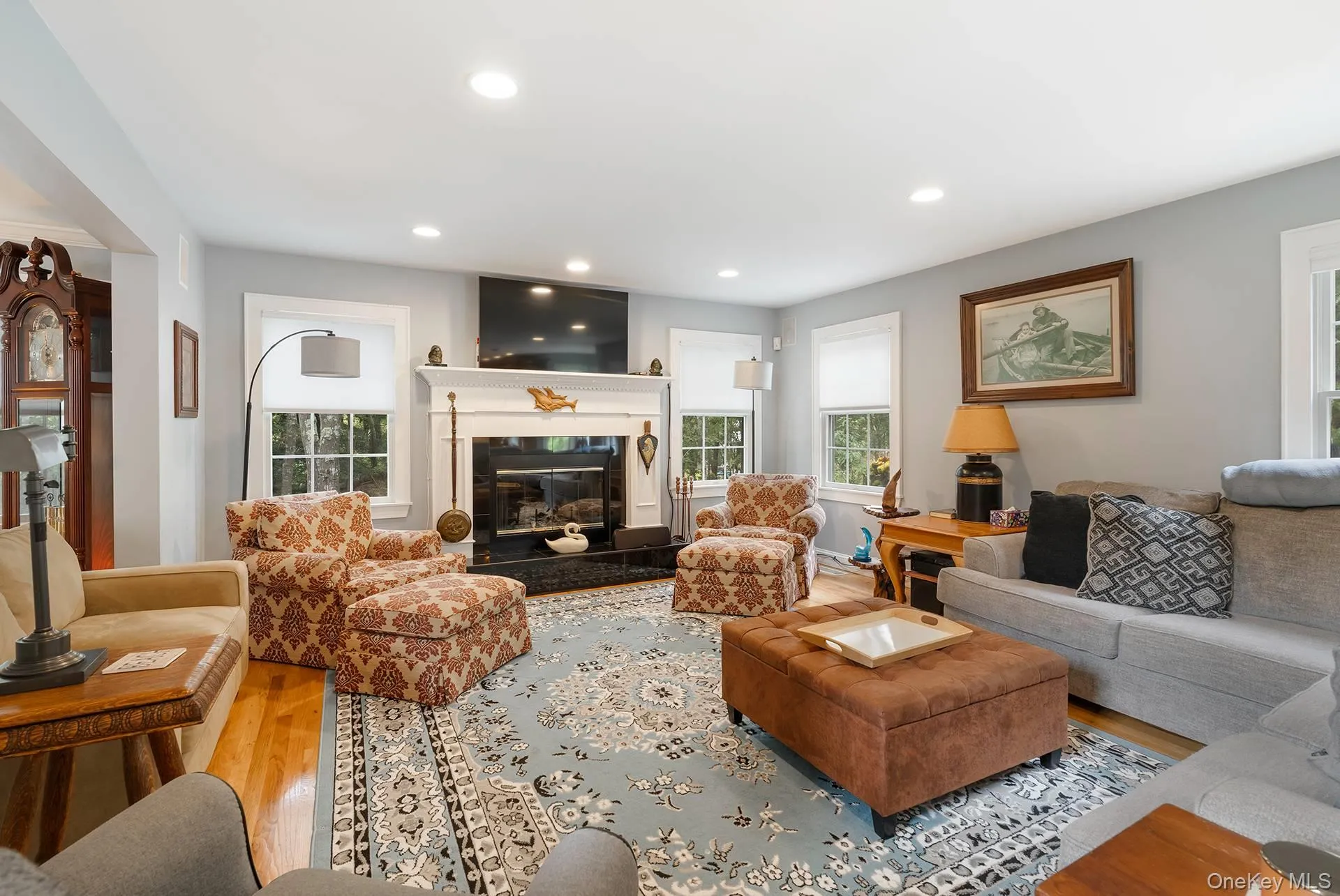 Living room with wood finished floors, recessed lighting, and a glass covered fireplace Living room with wood finished floors, recessed lighting, and a glass covered fireplace