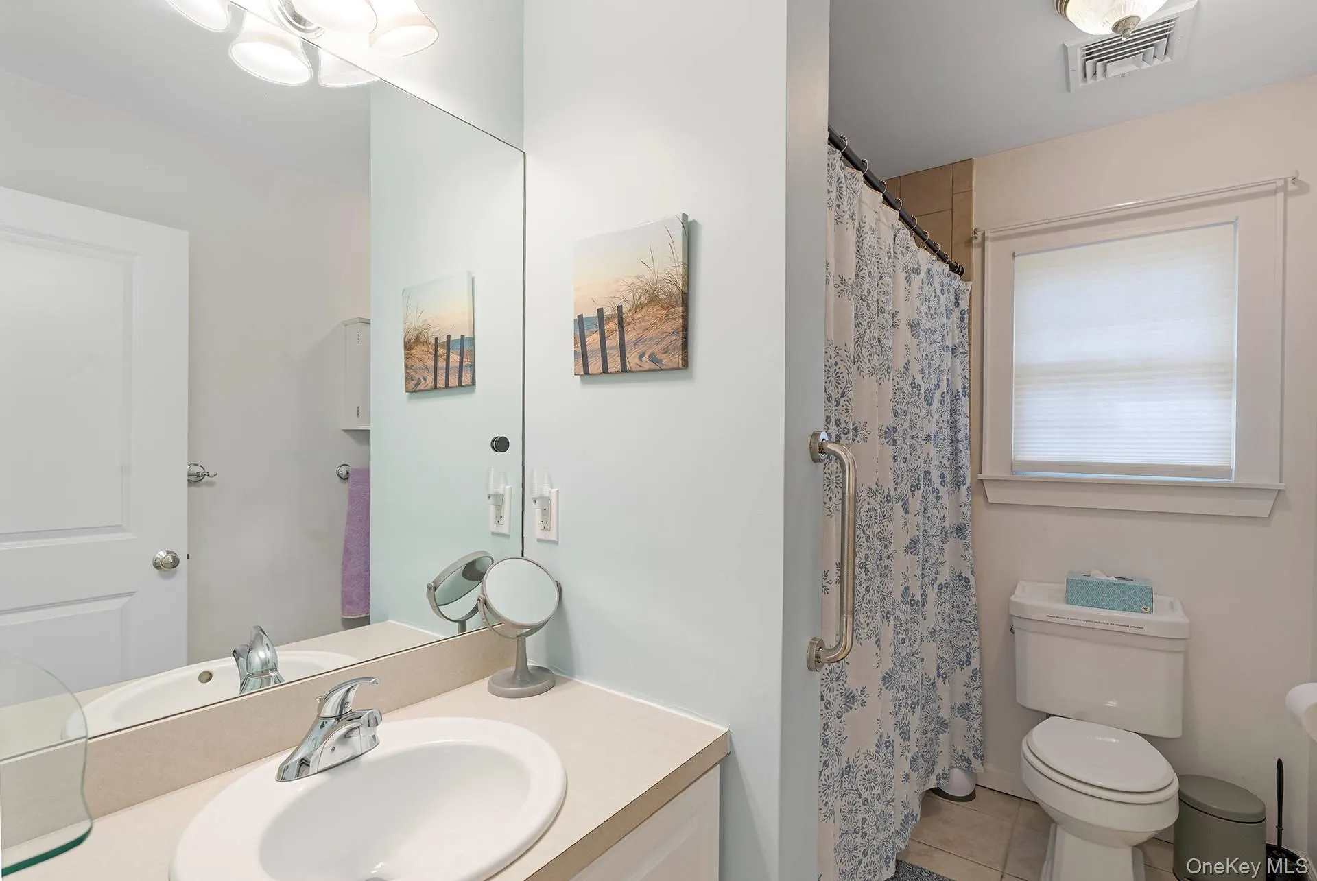 Bathroom featuring light tile patterned flooring, vanity, and a shower with curtain Bathroom featuring light tile patterned flooring, vanity, and a shower with curtain