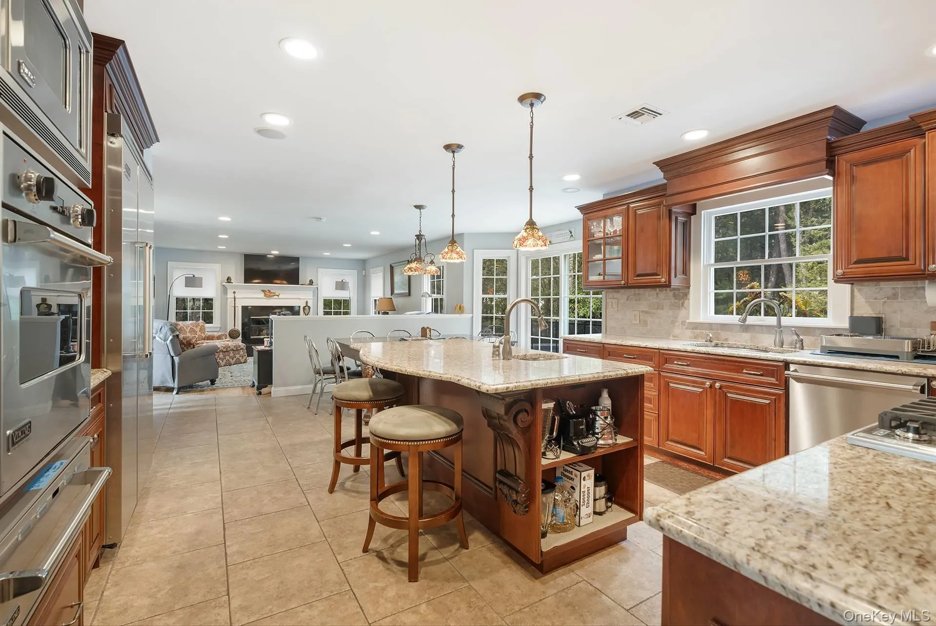 Kitchen with a breakfast bar, open shelves, open floor plan, light stone countertops, and a warming drawer Kitchen with a breakfast bar, open shelves, open floor plan, light stone countertops, and a warming drawer