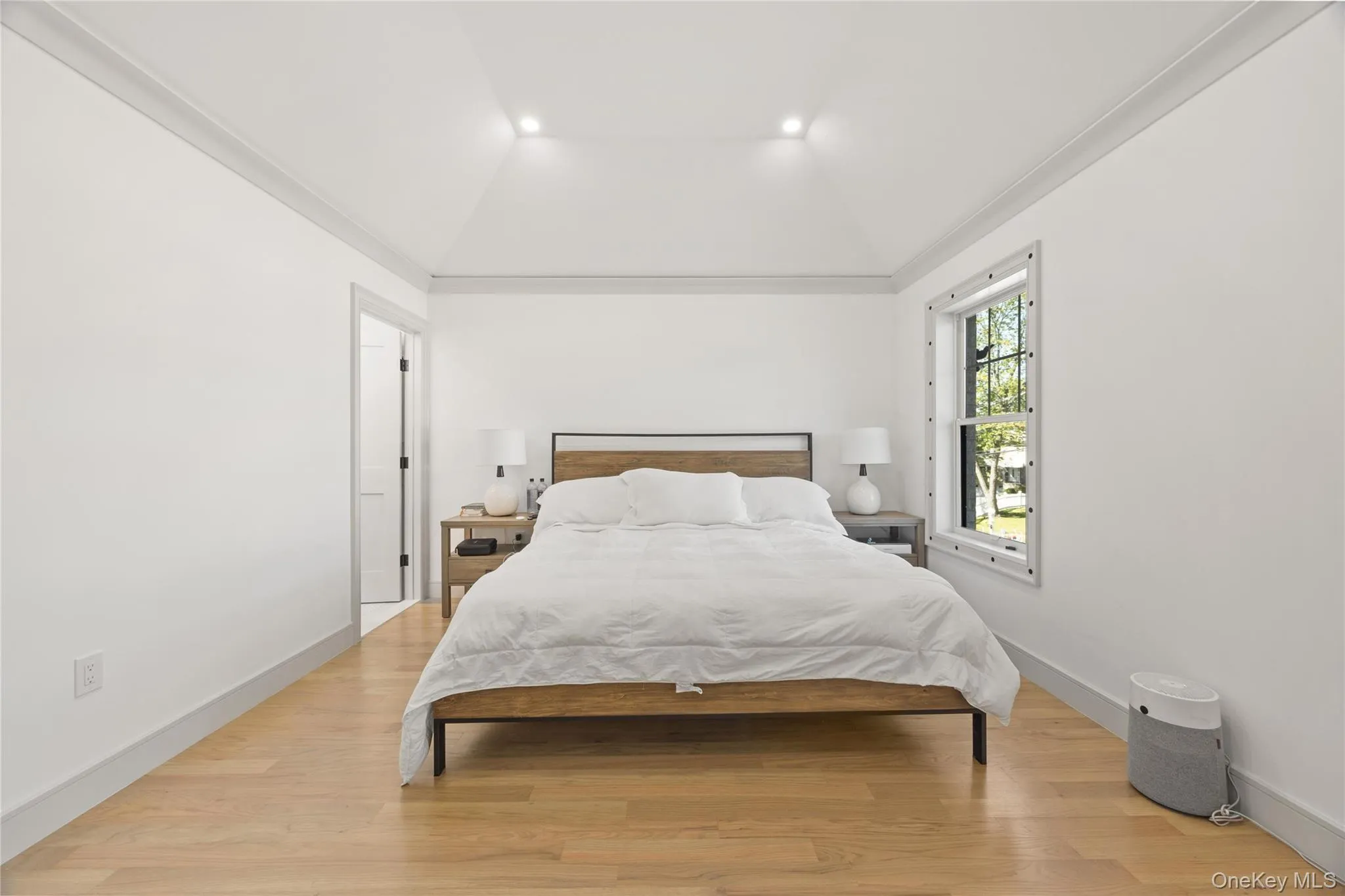 Bedroom featuring ornamental molding, light wood finished floors, vaulted ceiling, and recessed lighting Bedroom featuring ornamental molding, light wood finished floors, vaulted ceiling, and recessed lighting