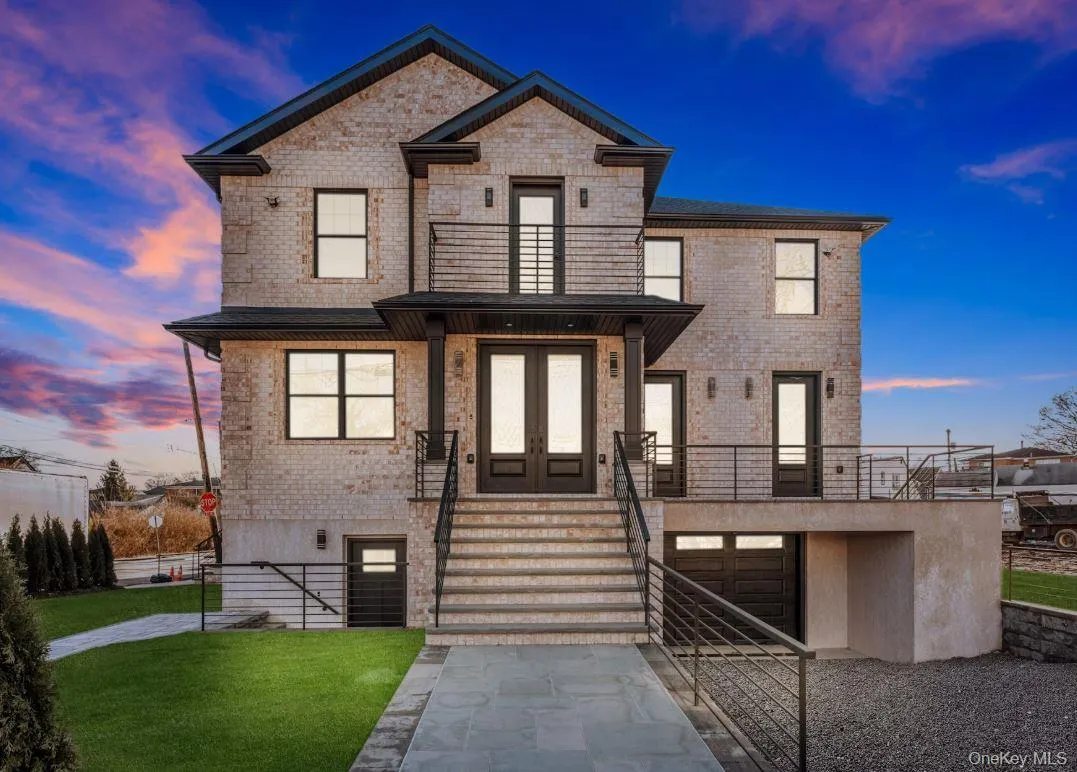 View of front of home featuring brick siding, a balcony, french doors, and stairs View of front of home featuring brick siding, a balcony, french doors, and stairs