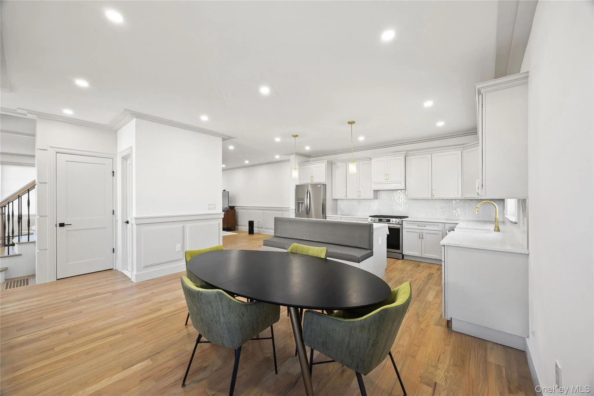 Dining area with wainscoting, light wood-style floors, a decorative wall, recessed lighting, and crown molding Dining area with wainscoting, light wood-style floors, a decorative wall, recessed lighting, and crown molding