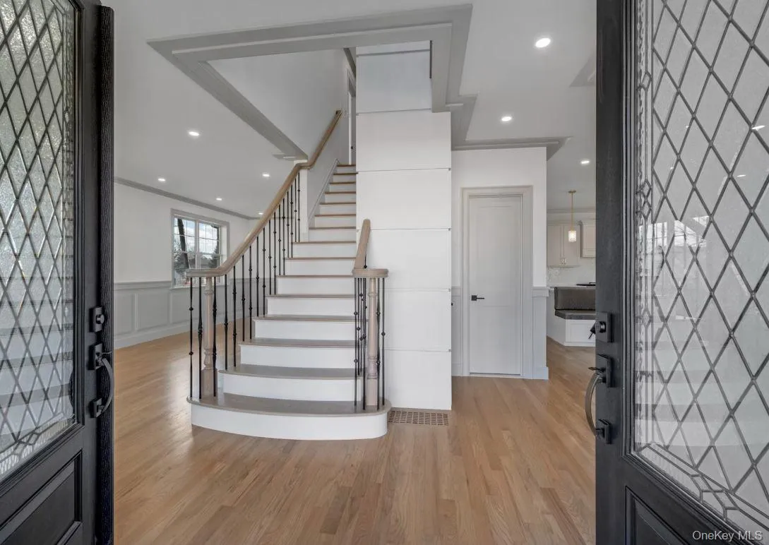 Foyer entrance featuring stairs, light wood-type flooring, recessed lighting, and a decorative wall Foyer entrance featuring stairs, light wood-type flooring, recessed lighting, and a decorative wall