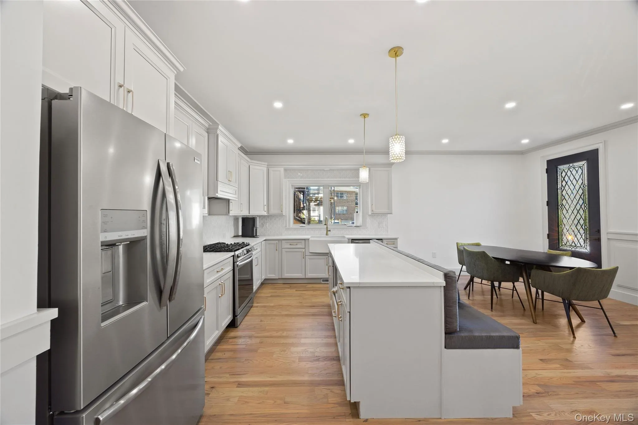 Kitchen featuring appliances with stainless steel finishes, white cabinetry, a center island, recessed lighting, and hanging light fixtures Kitchen featuring appliances with stainless steel finishes, white cabinetry, a center island, recessed lighting, and hanging light fixtures