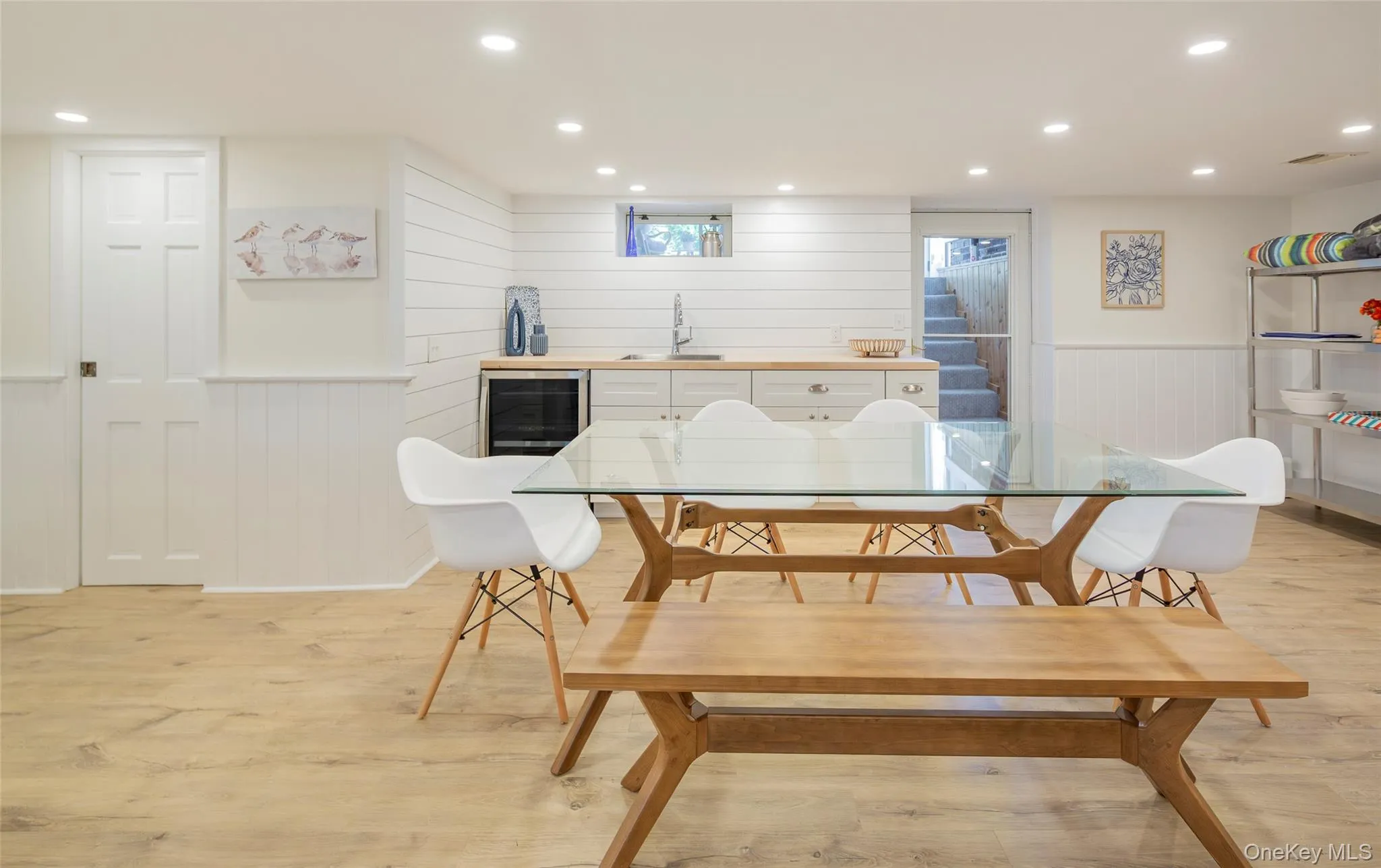 Dining space featuring recessed lighting, wainscoting, wood walls, light wood-type flooring, and beverage cooler Dining space featuring recessed lighting, wainscoting, wood walls, light wood-type flooring, and beverage cooler