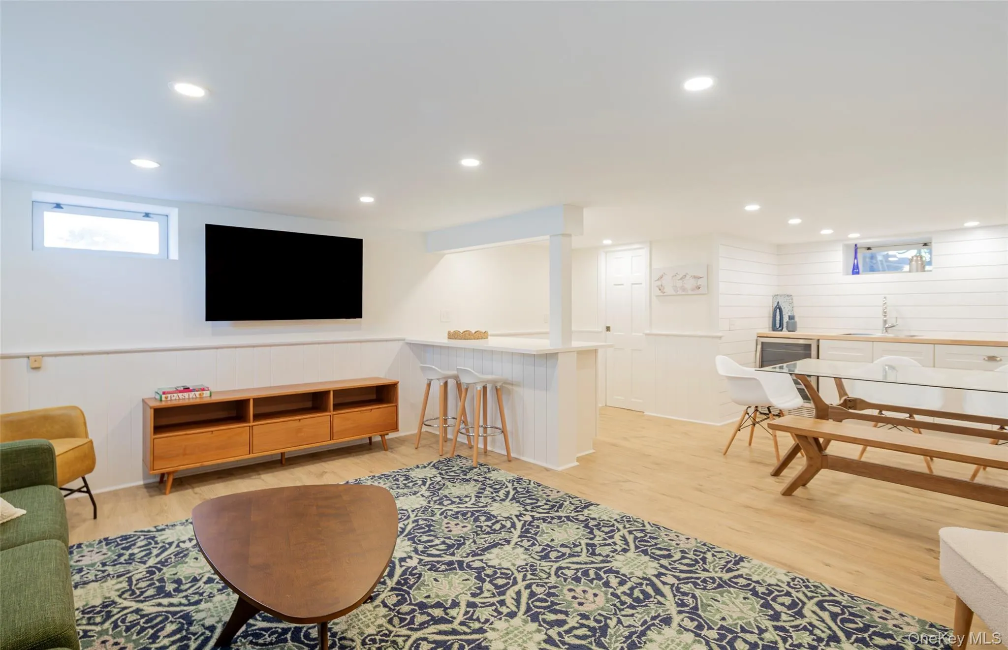 Living area with plenty of natural light, wood walls, light wood-style floors, recessed lighting, and wainscoting Living area with plenty of natural light, wood walls, light wood-style floors, recessed lighting, and wainscoting