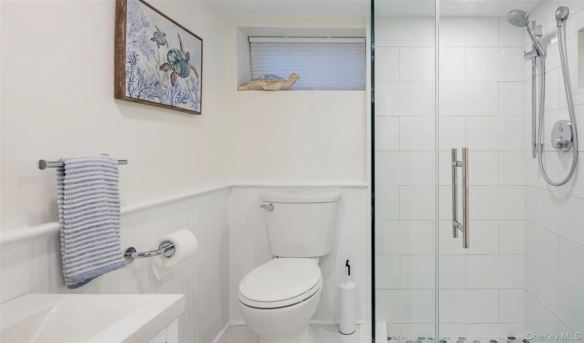 Full bath with a shower stall and wainscoting Full bath with a shower stall and wainscoting