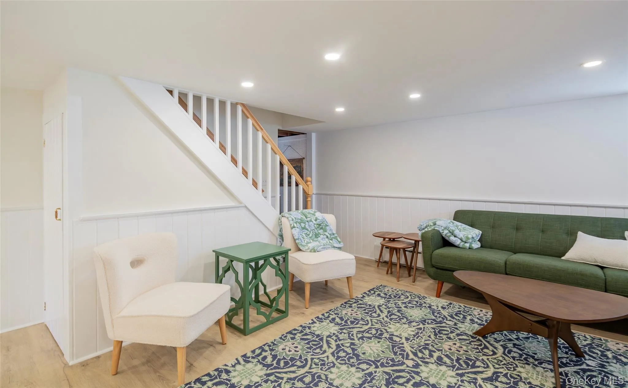 Living area featuring wood finished floors, recessed lighting, stairs, and a wainscoted wall Living area featuring wood finished floors, recessed lighting, stairs, and a wainscoted wall
