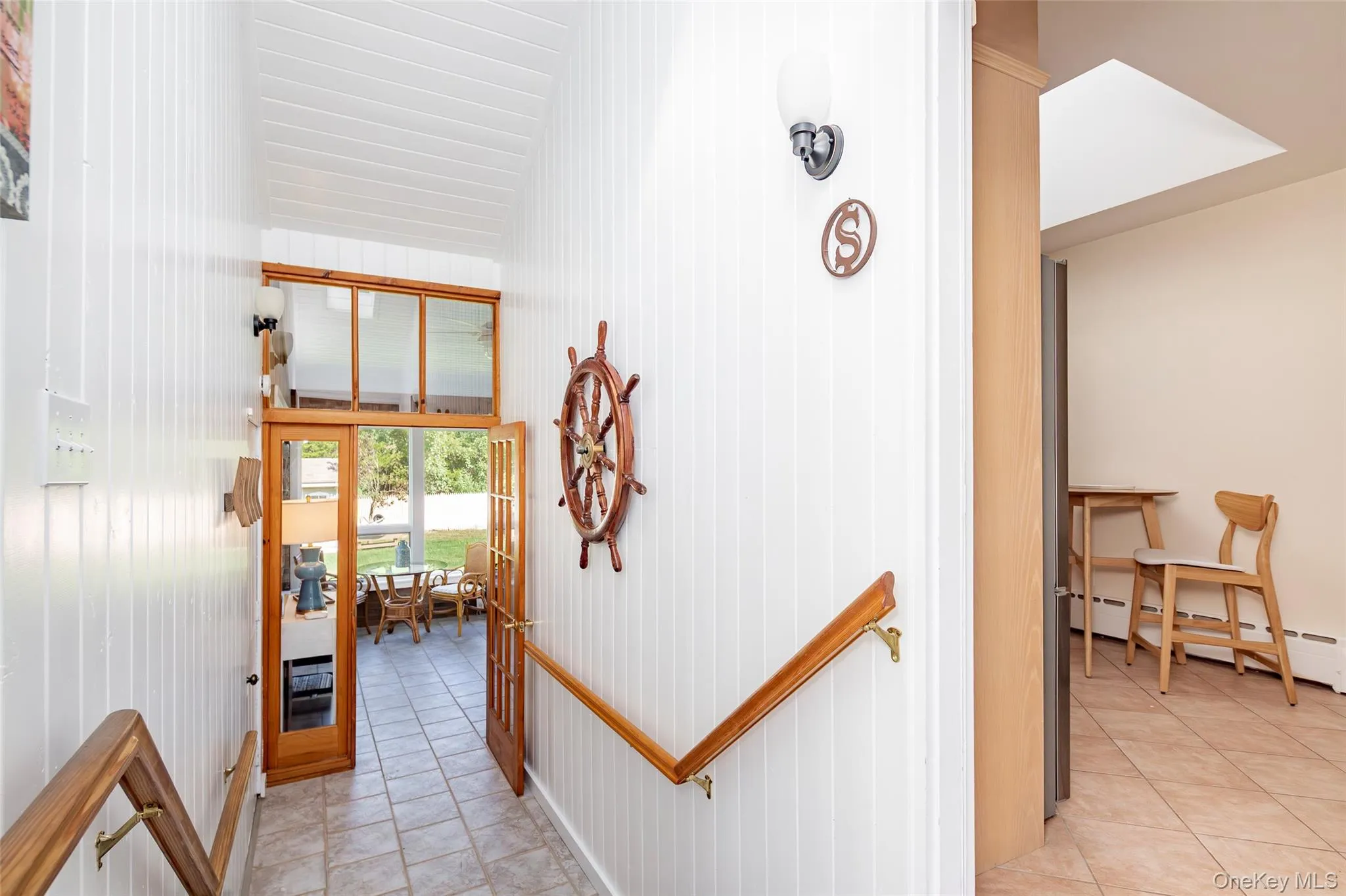 Corridor with light tile patterned flooring and a baseboard heating unit Corridor with light tile patterned flooring and a baseboard heating unit
