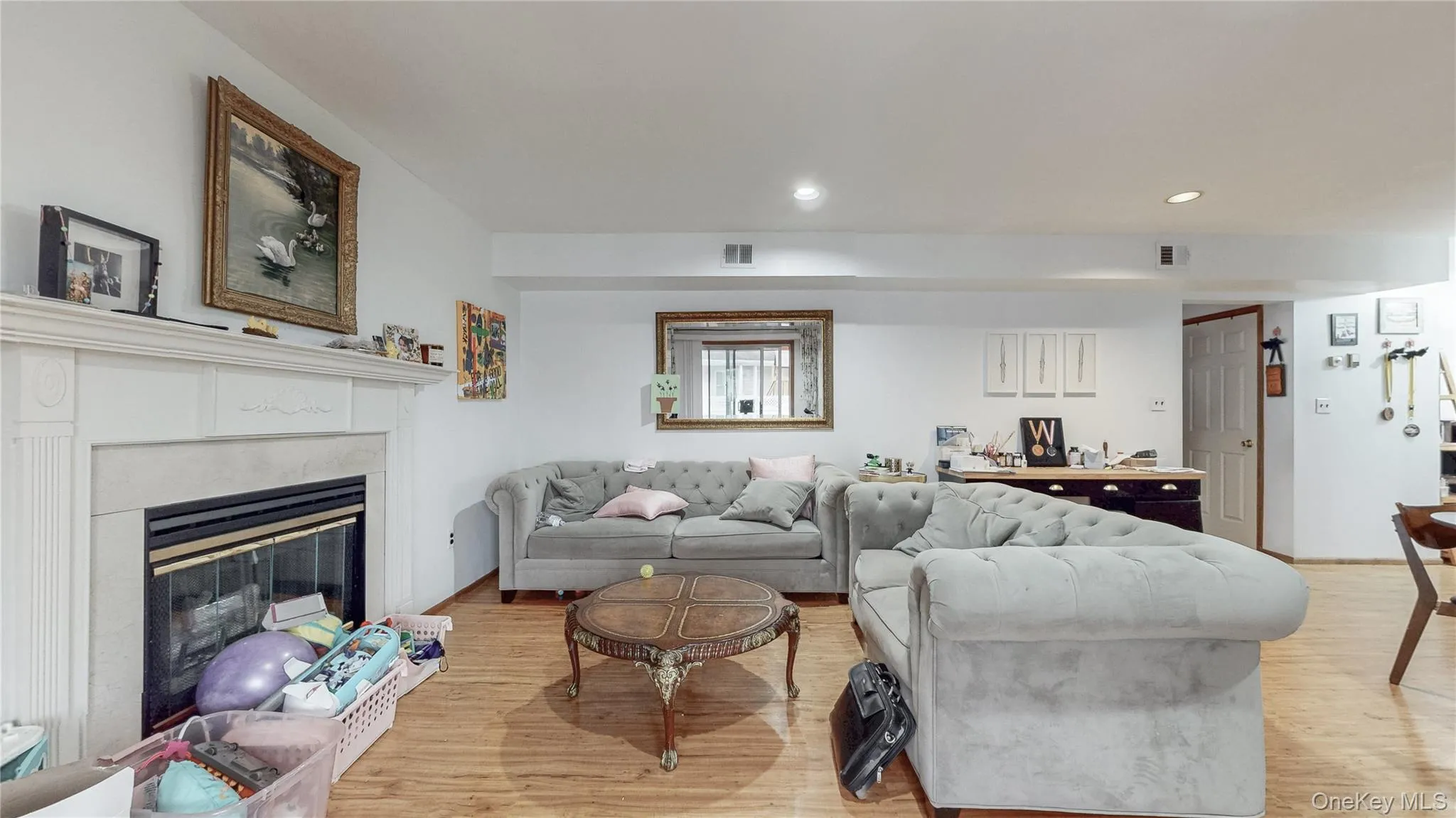 Living room with light wood-style floors, a glass covered fireplace, and recessed lighting Living room with light wood-style floors, a glass covered fireplace, and recessed lighting