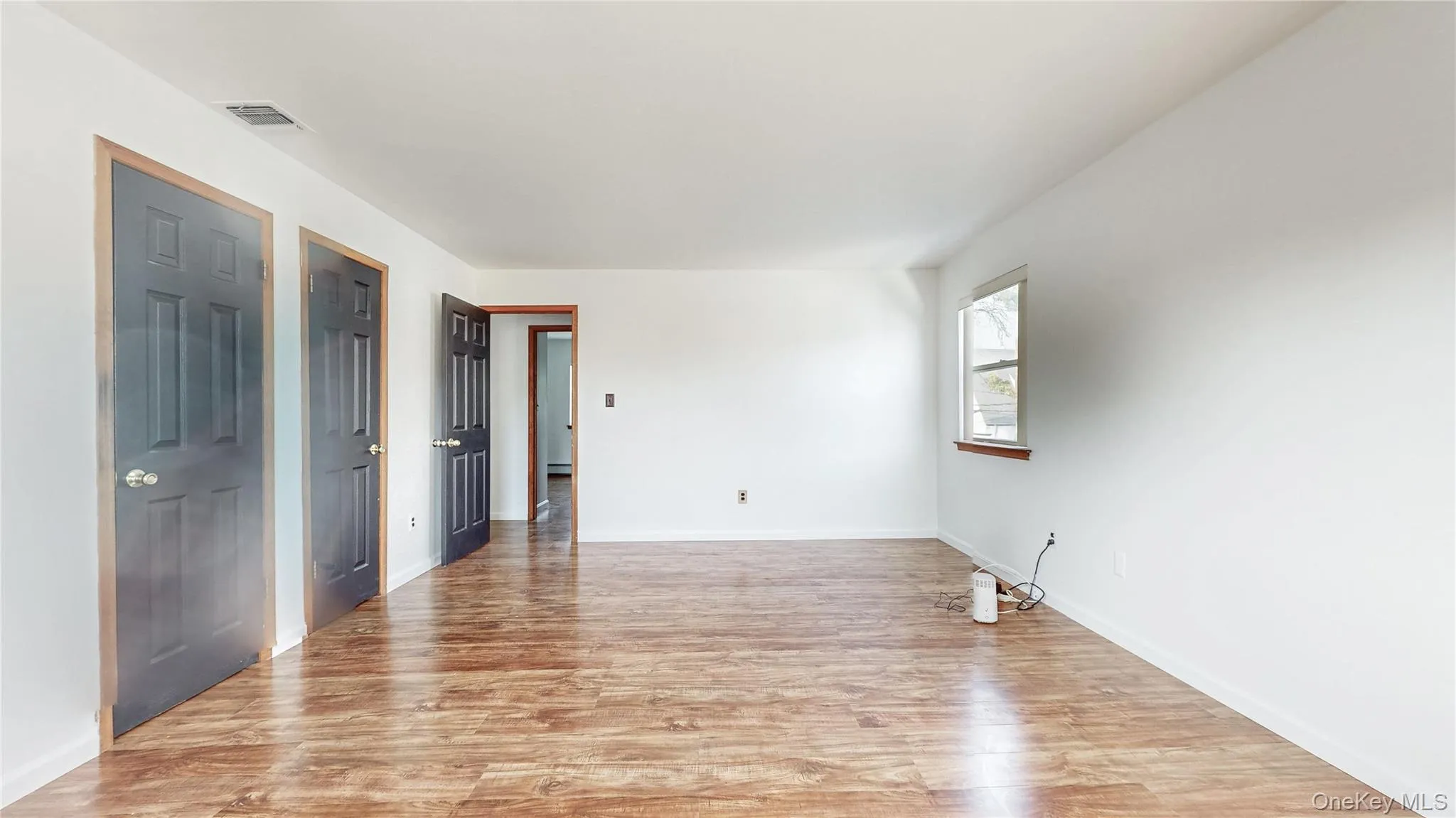 Unfurnished room with light wood-style floors and baseboards Unfurnished room with light wood-style floors and baseboards