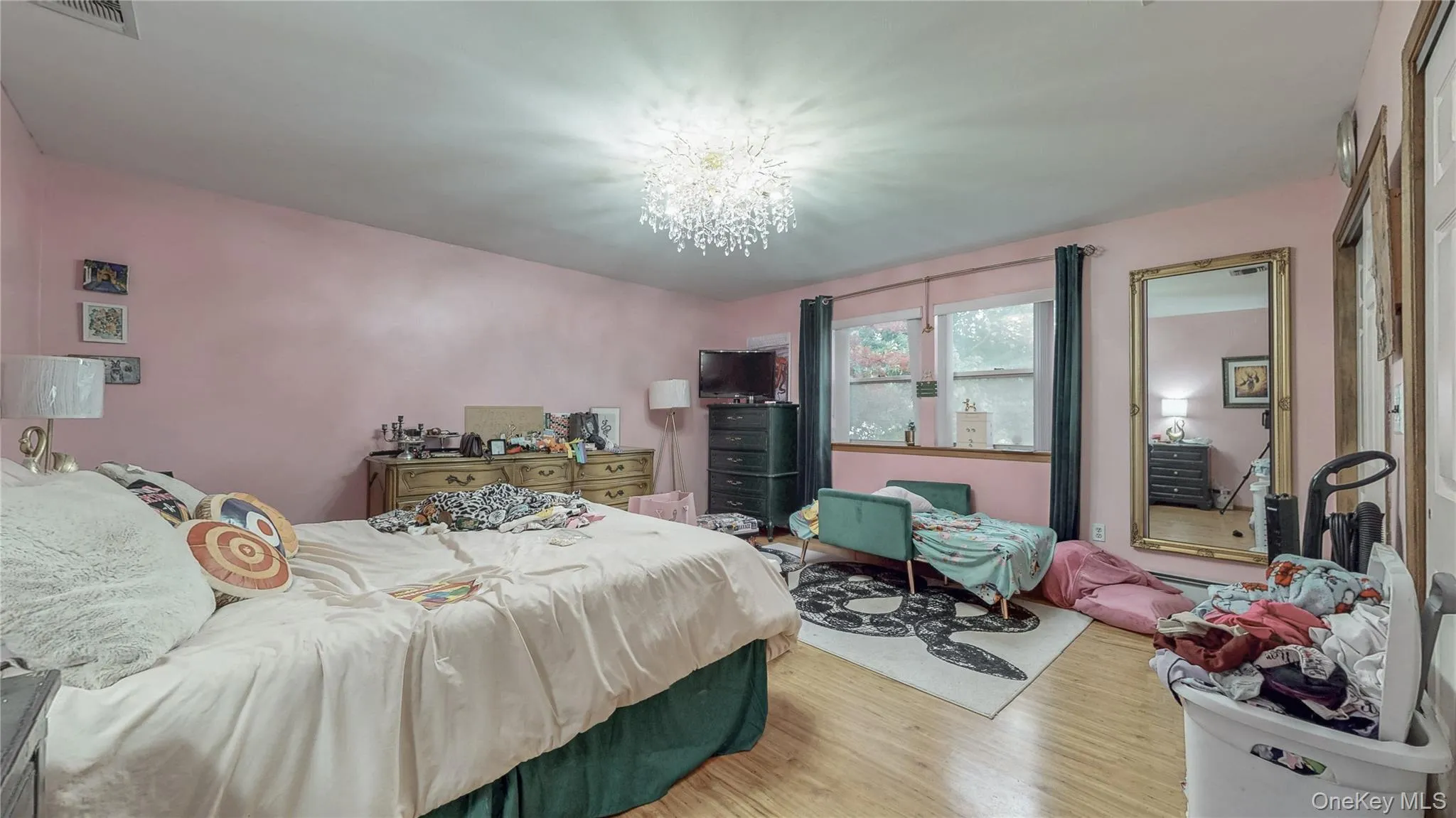 Bedroom featuring wood finished floors and a chandelier Bedroom featuring wood finished floors and a chandelier