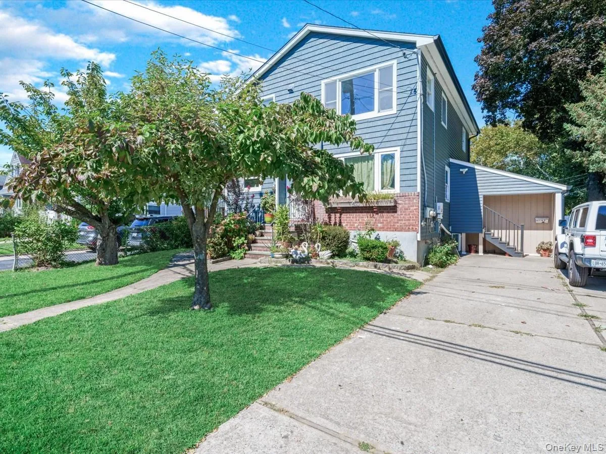 Traditional-style home featuring brick siding, a front yard, and stairway Traditional-style home featuring brick siding, a front yard, and stairway