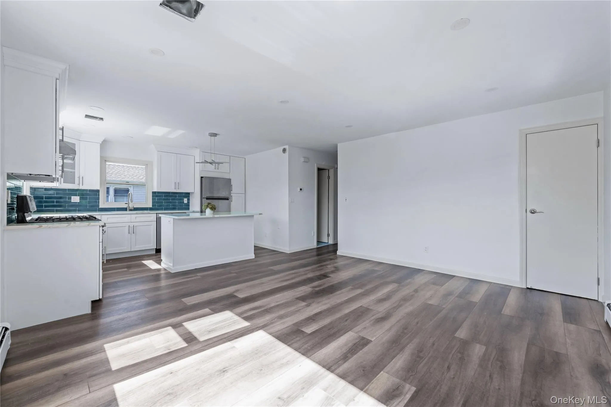 Unfurnished living room featuring dark wood-style flooring and baseboards Unfurnished living room featuring dark wood-style flooring and baseboards