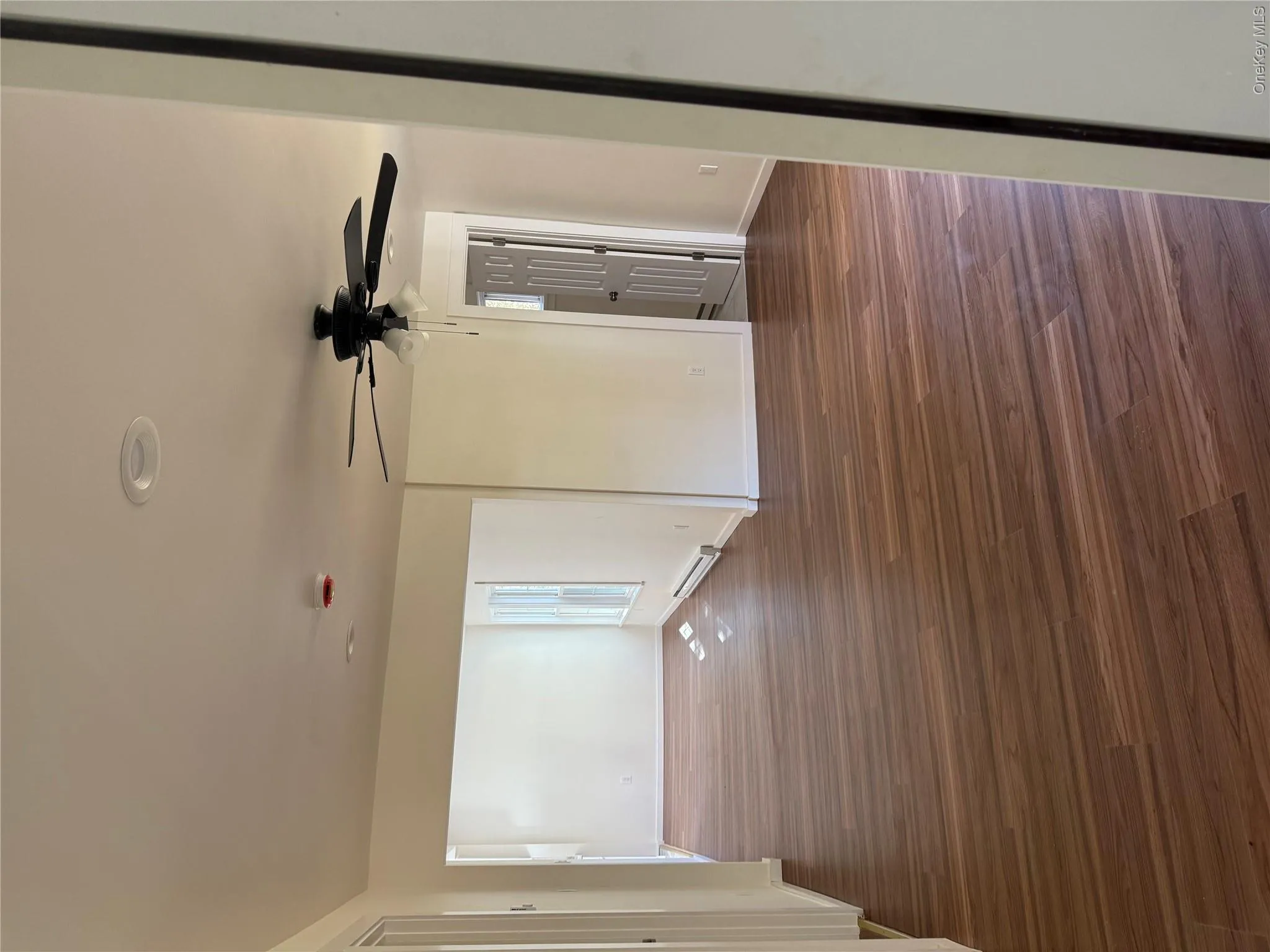 Unfurnished room with dark wood-style floors, a baseboard radiator, and ceiling fan Unfurnished room with dark wood-style floors, a baseboard radiator, and ceiling fan
