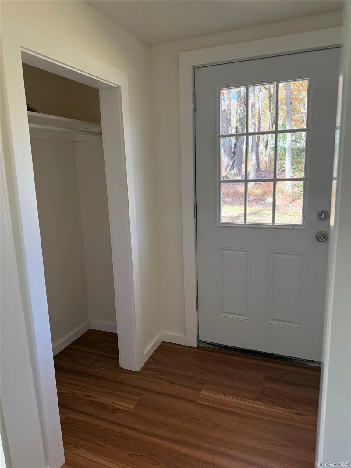 Doorway to outside featuring wood finished floors and baseboards Doorway to outside featuring wood finished floors and baseboards