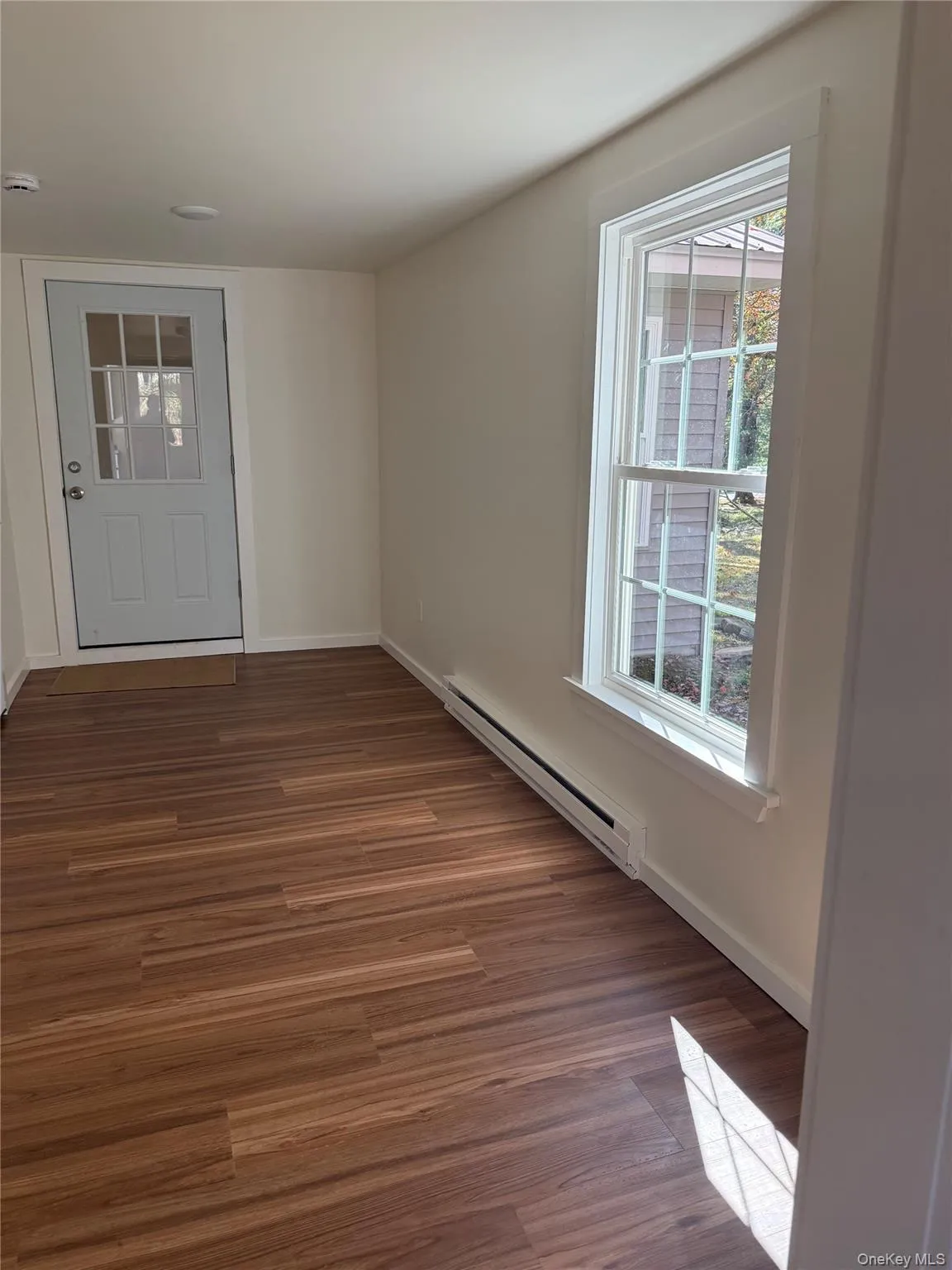 Breez way/Foyer with a baseboard radiator and dark wood-type flooring Breez way/Foyer with a baseboard radiator and dark wood-type flooring