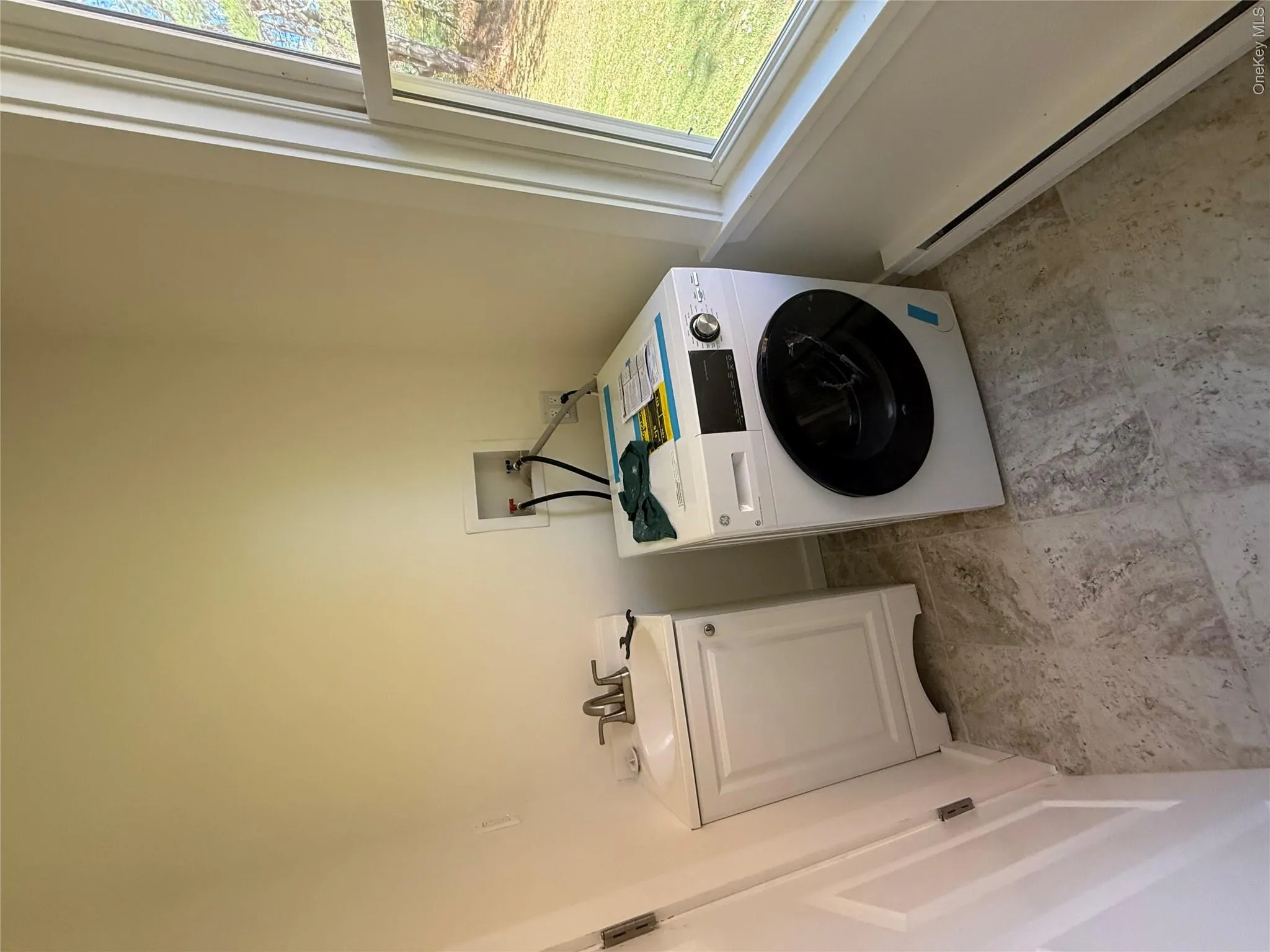 Laundry area featuring baseboard heating, washer / dryer, and cabinet space Laundry area featuring baseboard heating, washer / dryer, and cabinet space