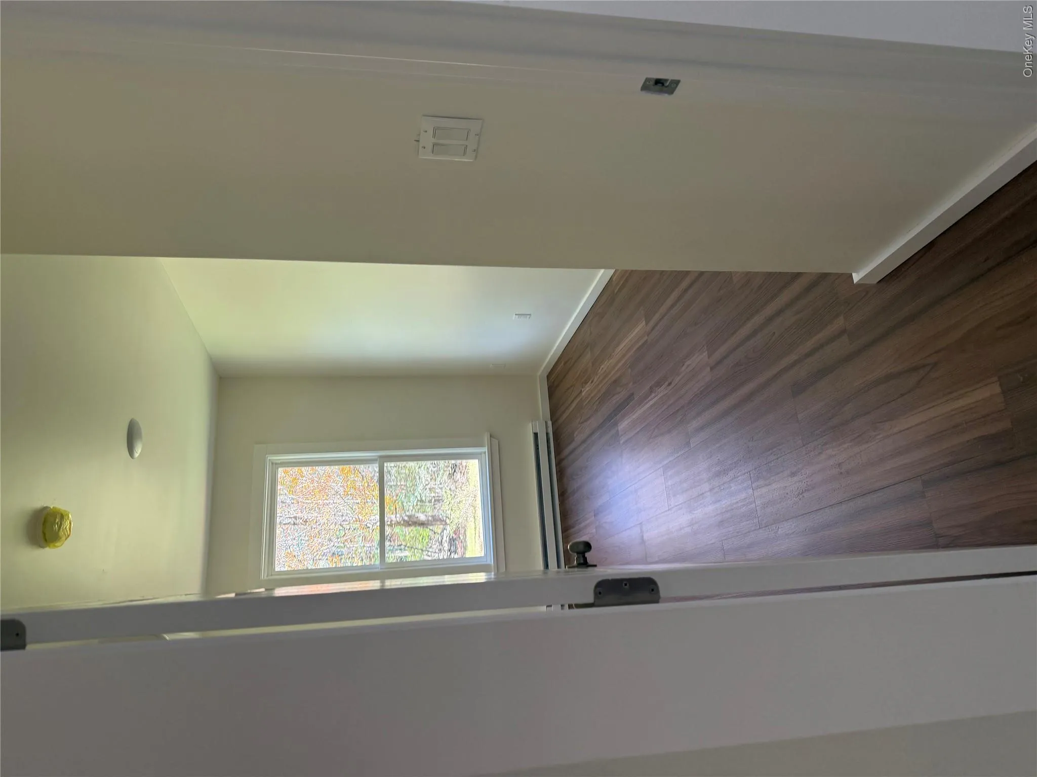 Spare room with dark wood finished floors, baseboard heating, and a smoke detector Spare room with dark wood finished floors, baseboard heating, and a smoke detector