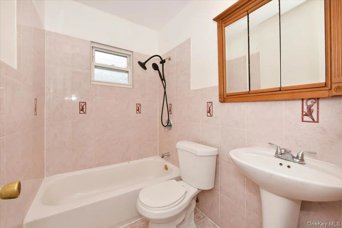 Bathroom featuring shower / tub combination and tile walls Bathroom featuring shower / tub combination and tile walls