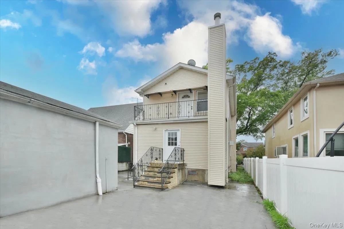 Back of property featuring a chimney and a balcony Back of property featuring a chimney and a balcony