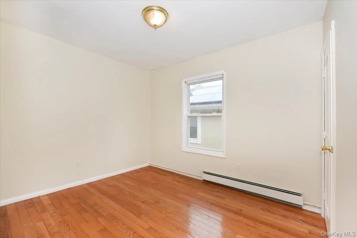 Unfurnished room with a baseboard heating unit and light wood-style flooring Unfurnished room with a baseboard heating unit and light wood-style flooring