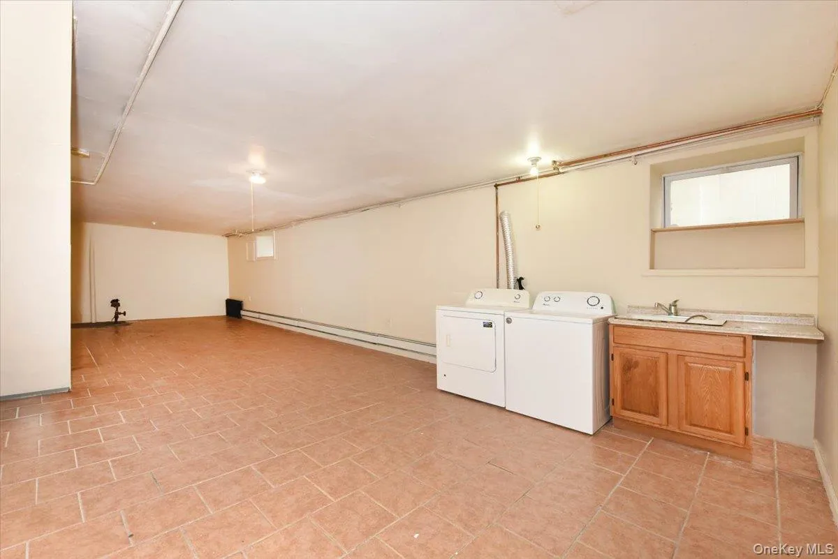Laundry room featuring a baseboard radiator and independent washer and dryer Laundry room featuring a baseboard radiator and independent washer and dryer