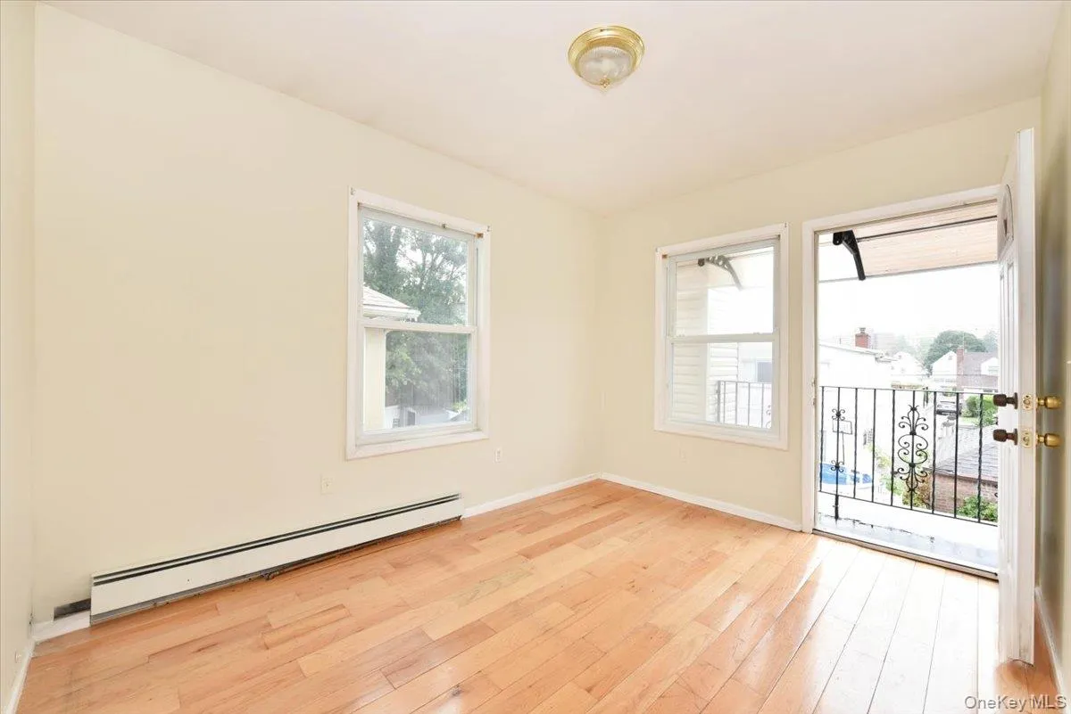 Unfurnished room with a baseboard radiator and light wood-style floors Unfurnished room with a baseboard radiator and light wood-style floors