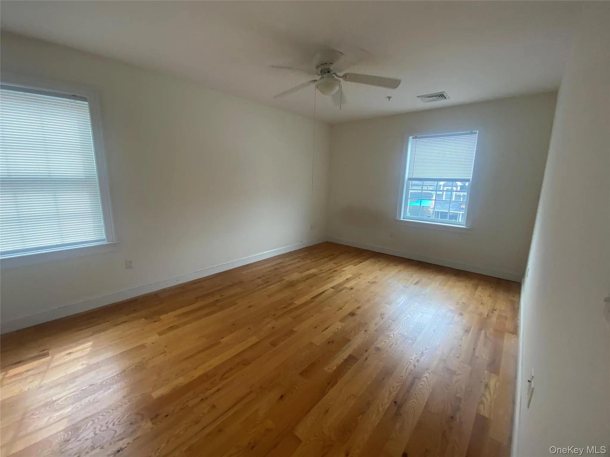 Unfurnished room featuring light wood finished floors and ceiling fan Unfurnished room featuring light wood finished floors and ceiling fan