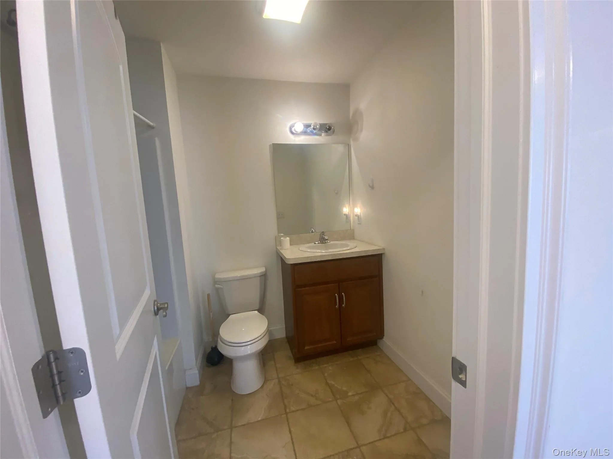 Half bath featuring vanity and light tile patterned floors Half bath featuring vanity and light tile patterned floors