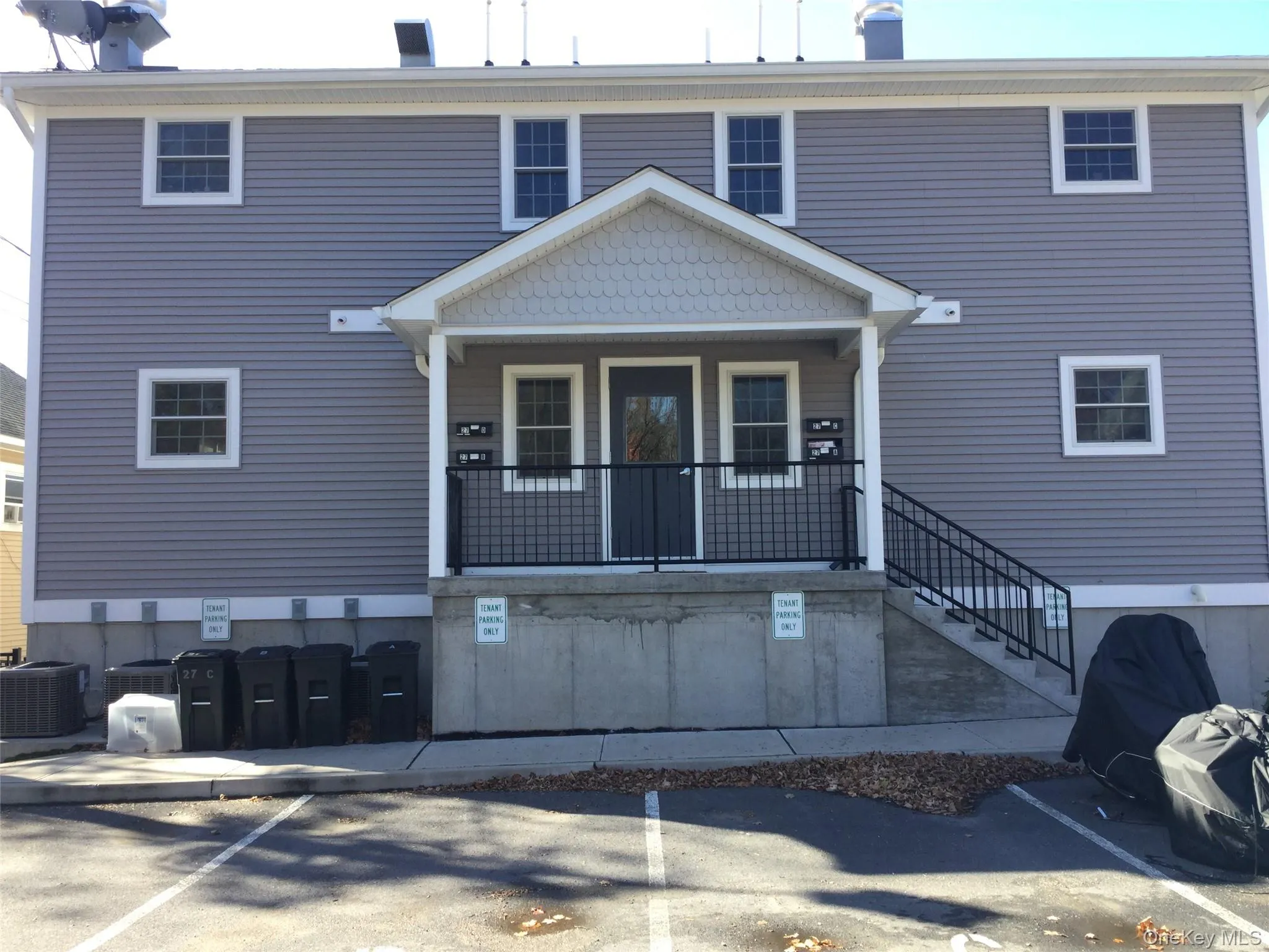 View of front of property with a porch and uncovered parking View of front of property with a porch and uncovered parking