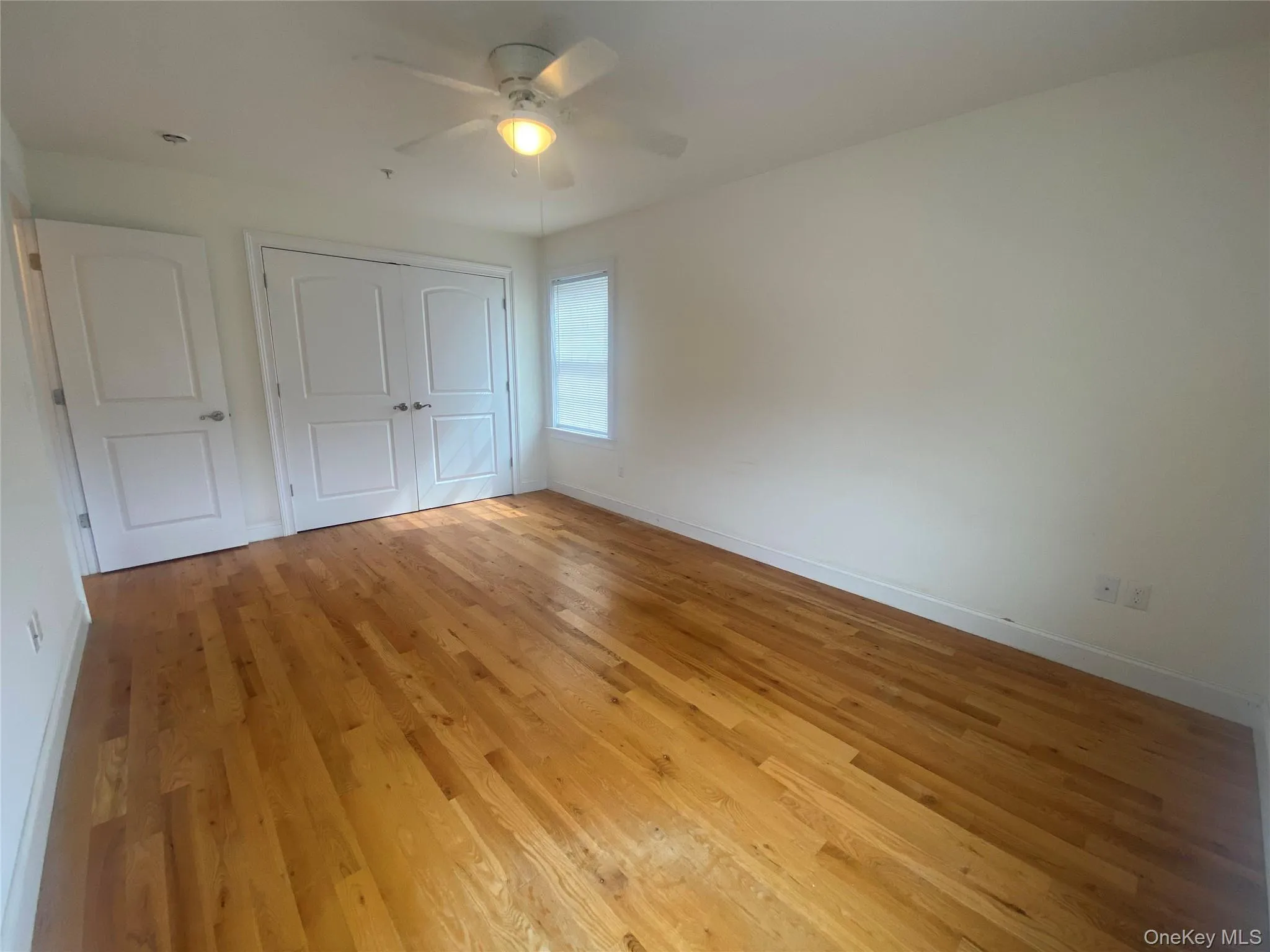 Unfurnished bedroom with light wood-style floors, ceiling fan, and a closet Unfurnished bedroom with light wood-style floors, ceiling fan, and a closet