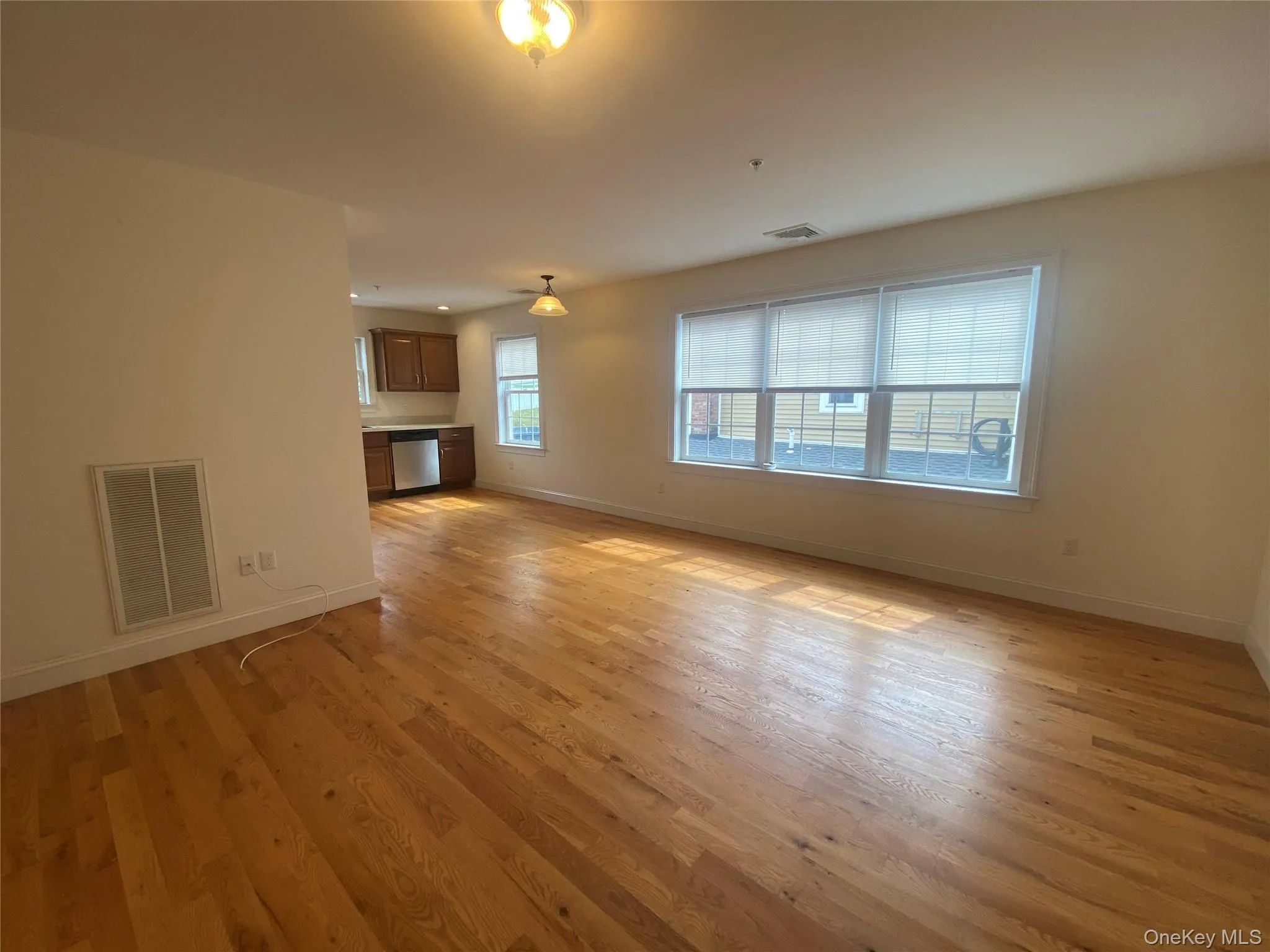 Unfurnished living room featuring baseboards and light wood-type flooring Unfurnished living room featuring baseboards and light wood-type flooring