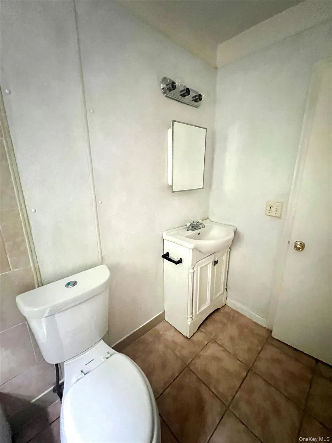 Half bath with vanity and dark tile patterned floors Half bath with vanity and dark tile patterned floors